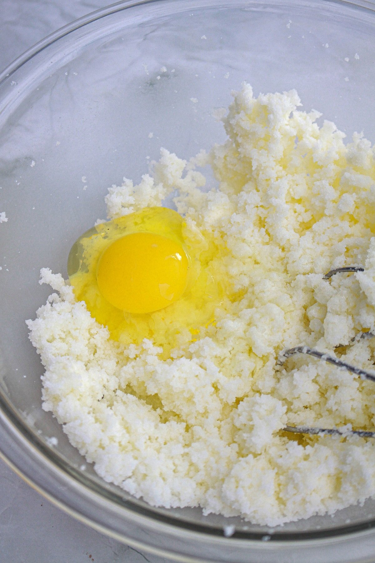 butter and sugar mixed in bowl with egg