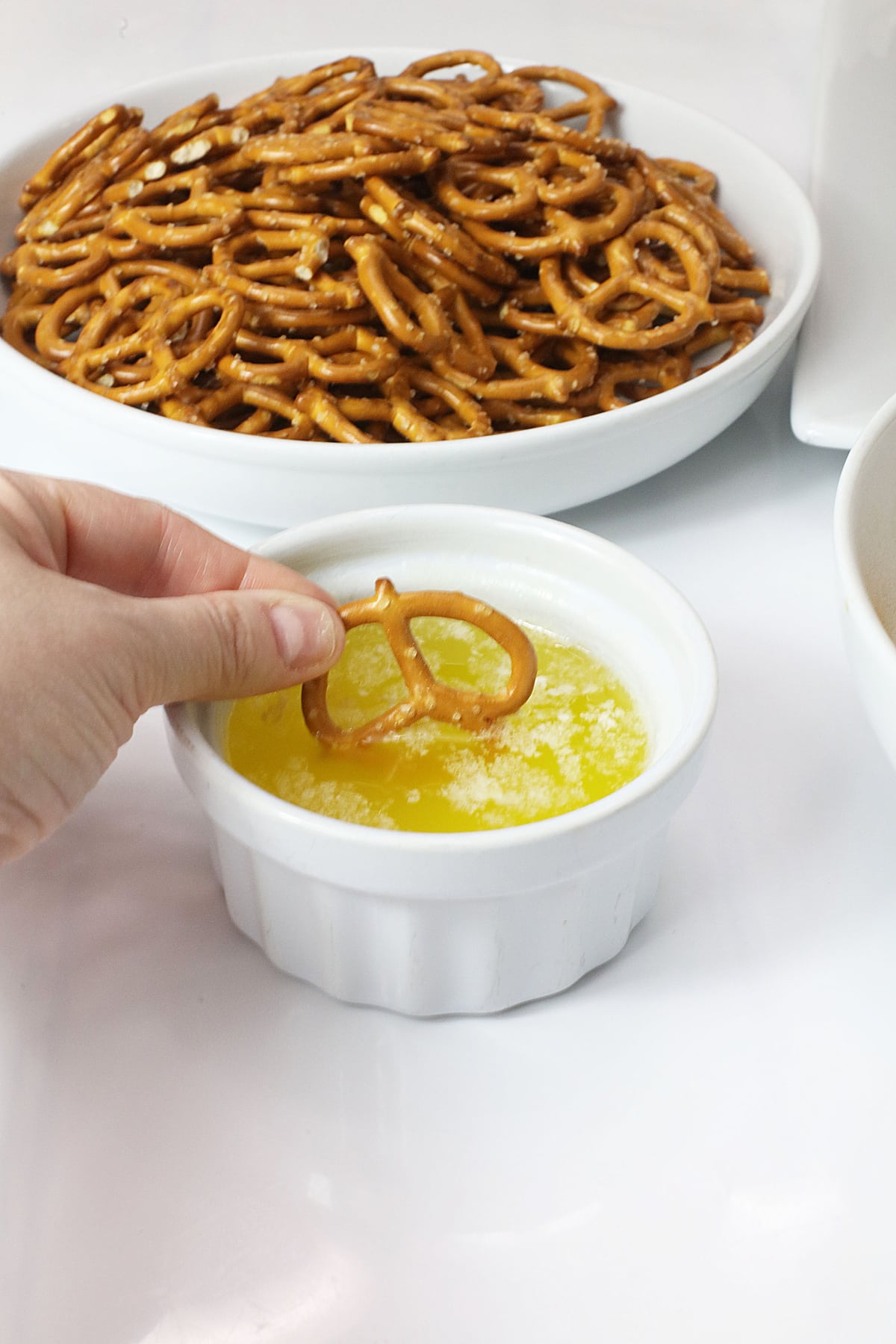 Dipping a pretzel in melted butter.
