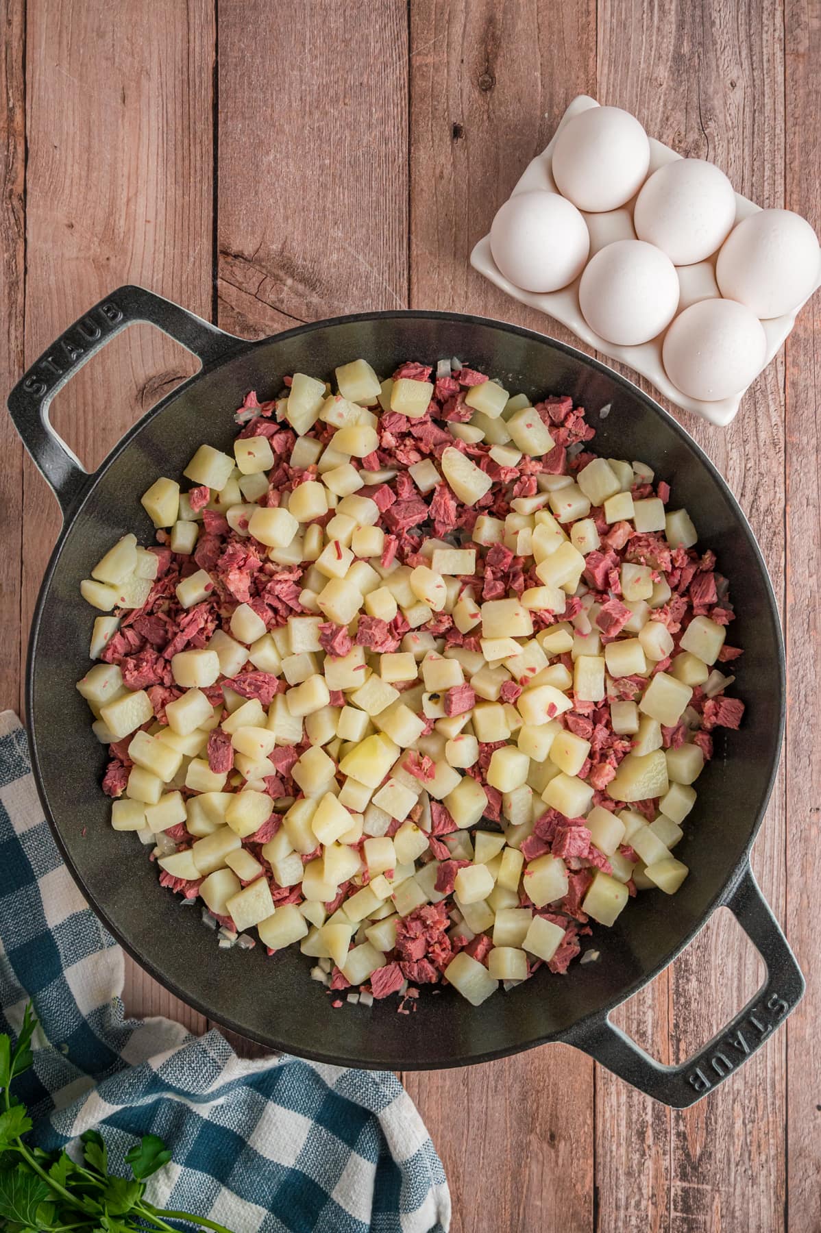 Diced potatoes and corned beef in a cast iron skillet.