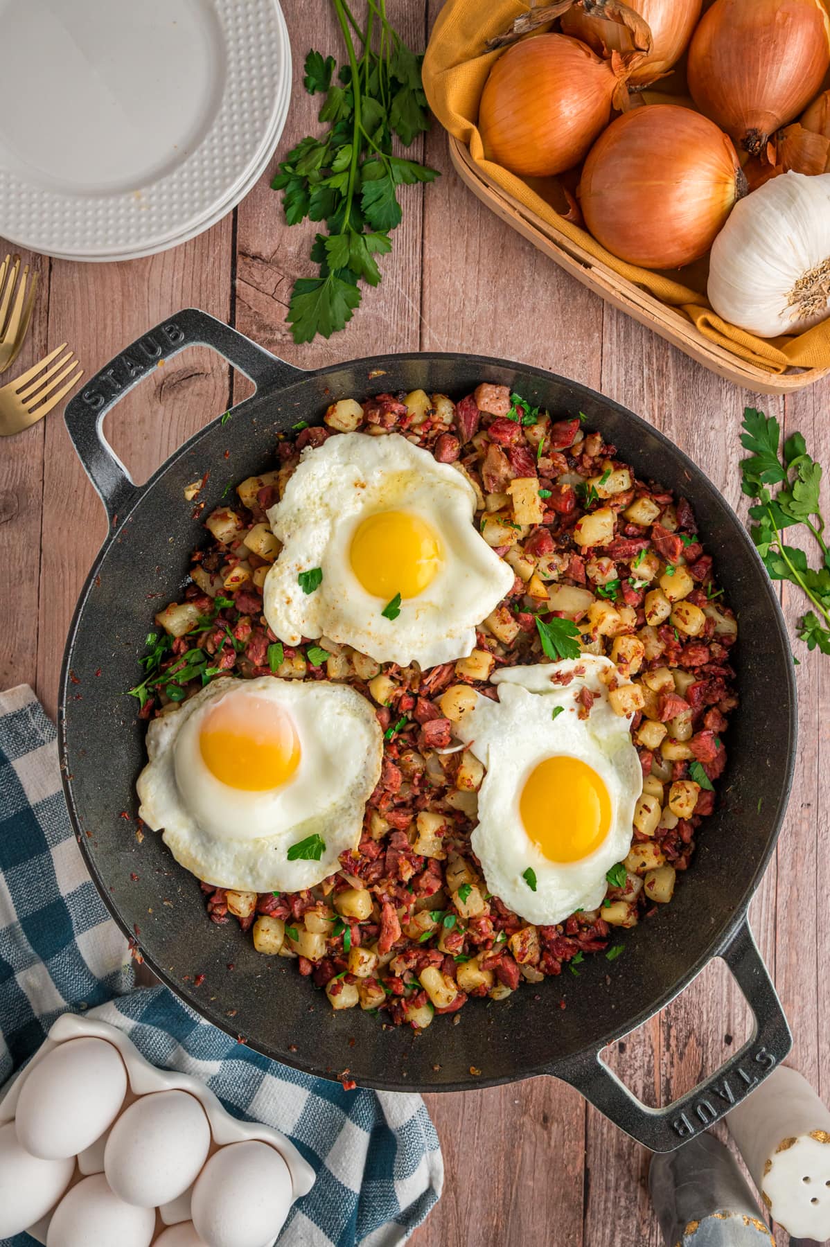 Fried eggs on top of corned beef hash in a cast iron skillet.