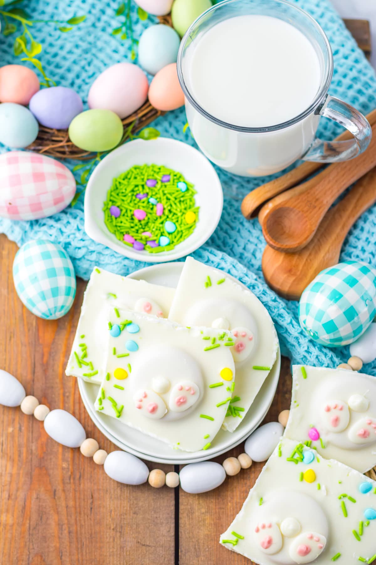 Milk and Easter bark pieces on a white plate with Easter decorations around them.