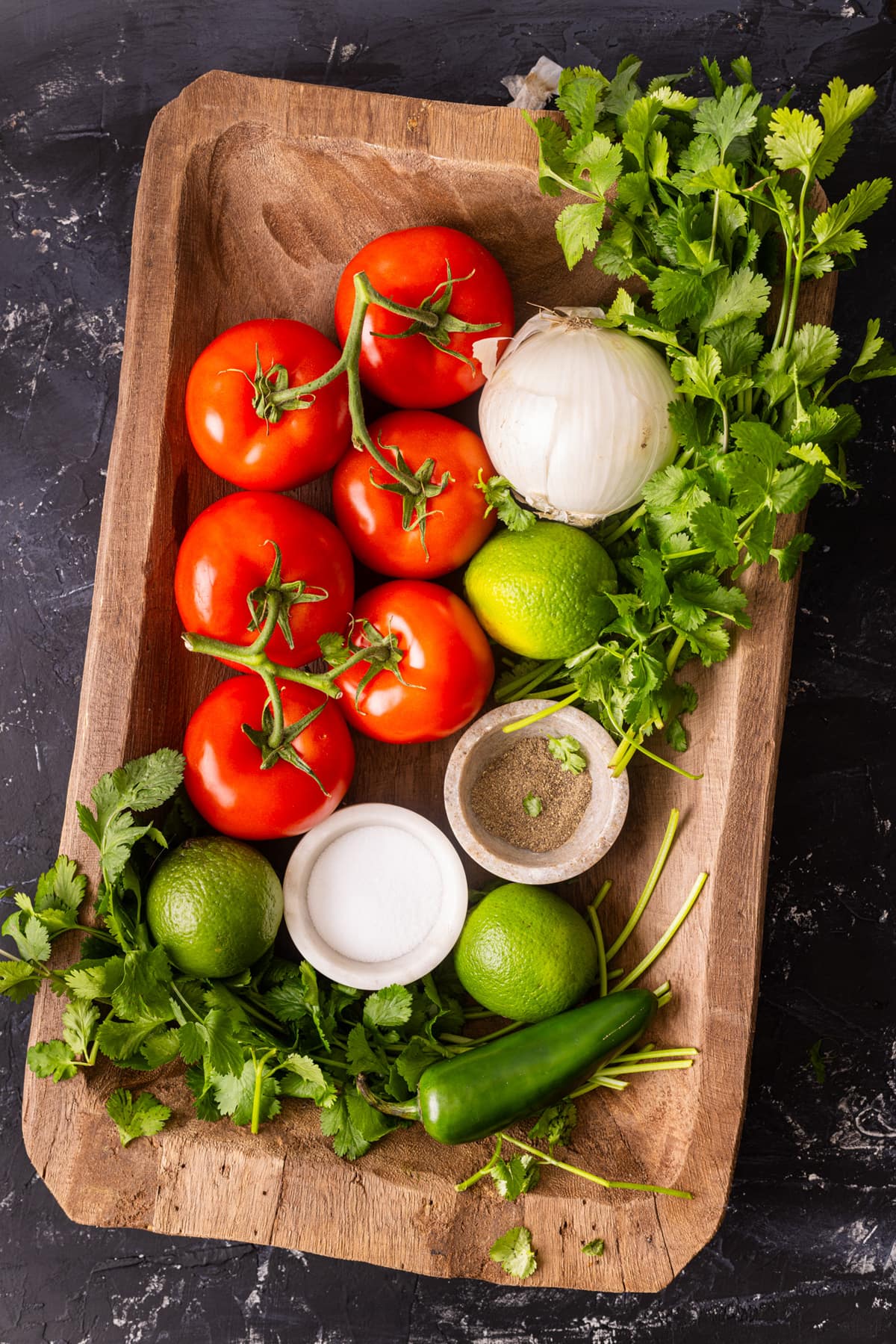Ingredients for Pico de Gallo in a wood tray.