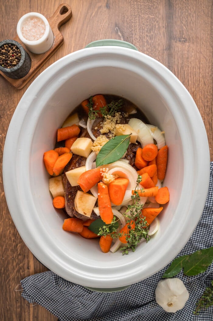Veggies over a pot roast in a slow cooker