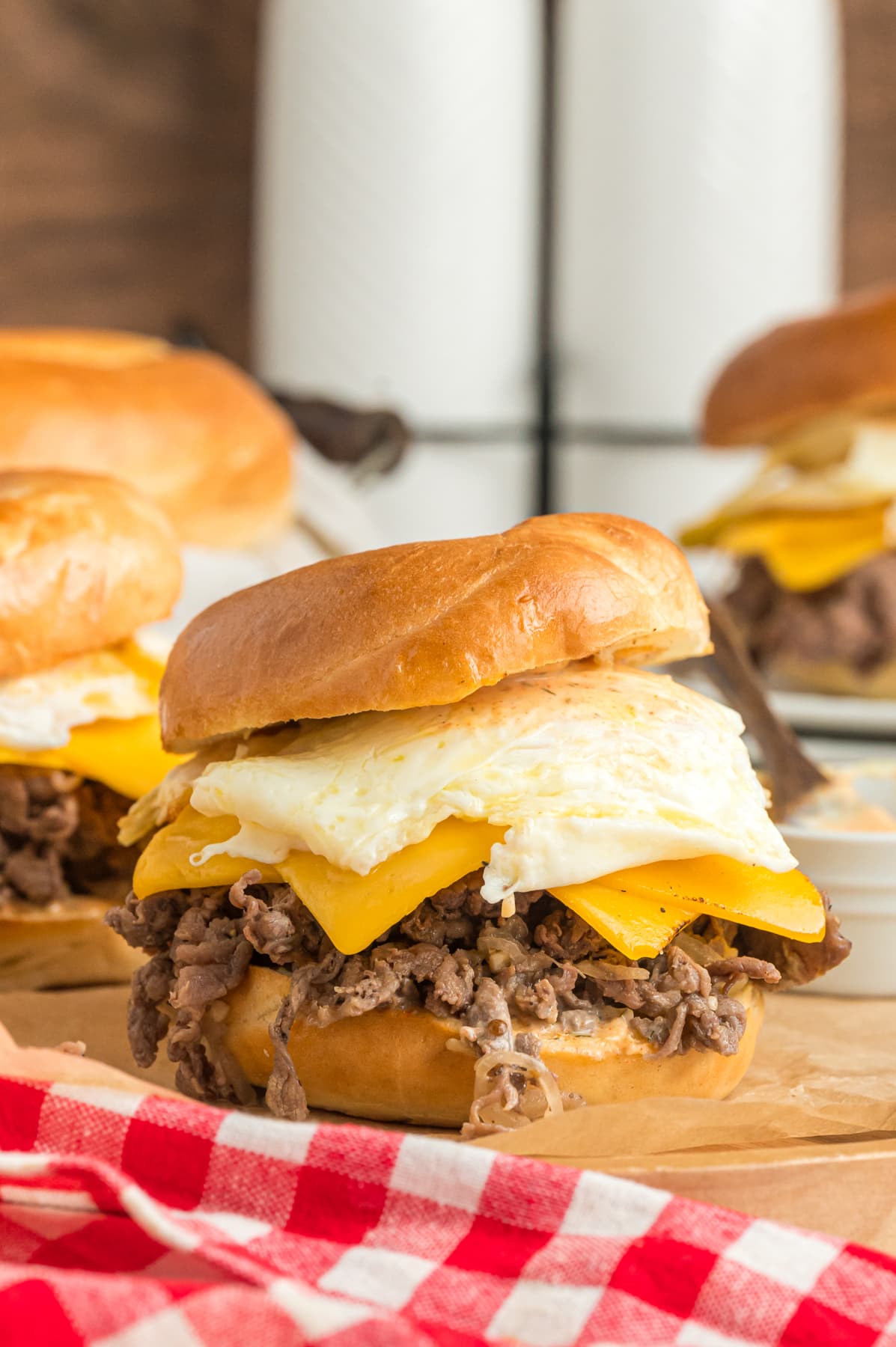 steak egg and cheese bagel served on wooden board