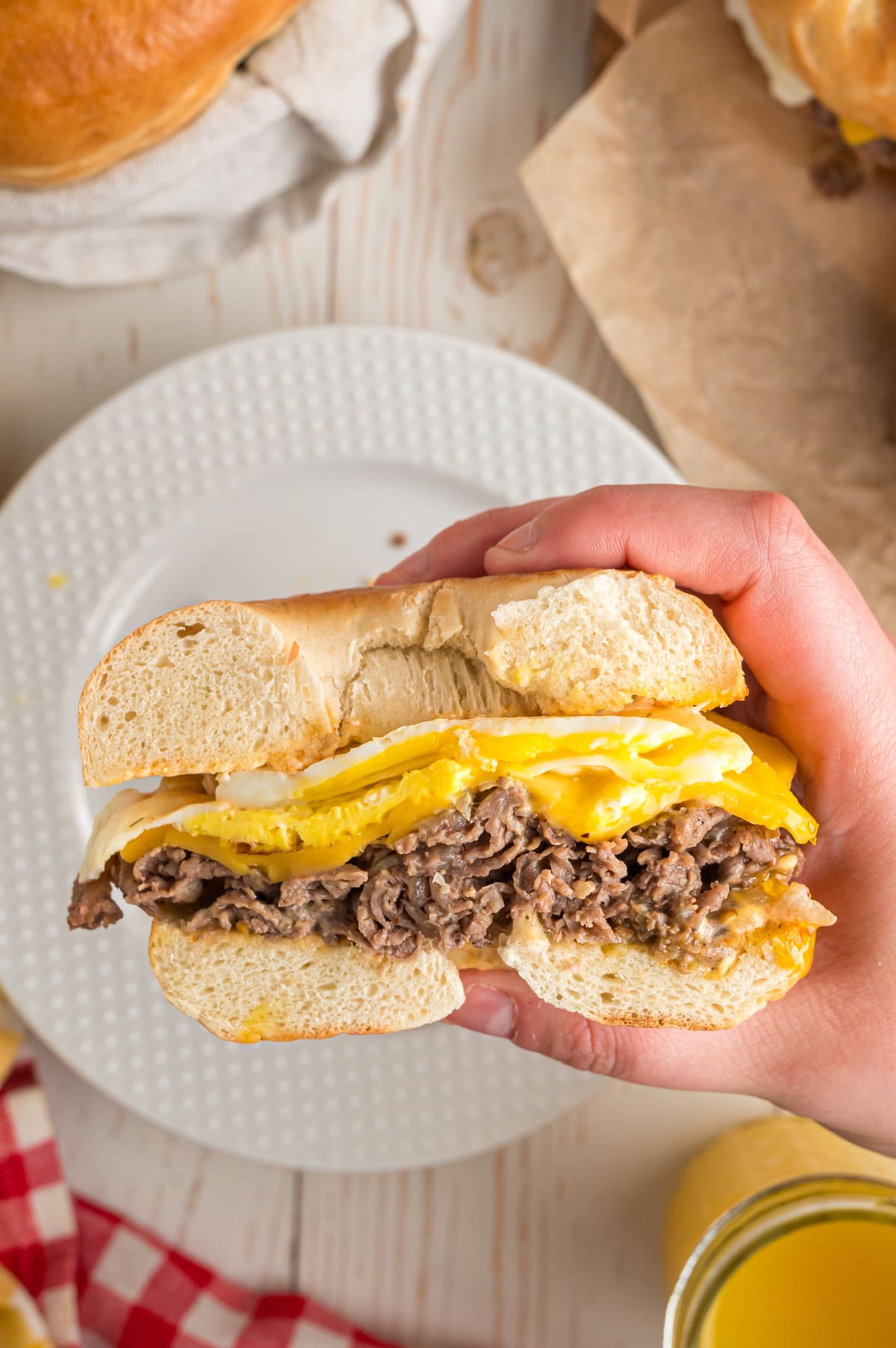 hand holding steak egg and cheese bagel