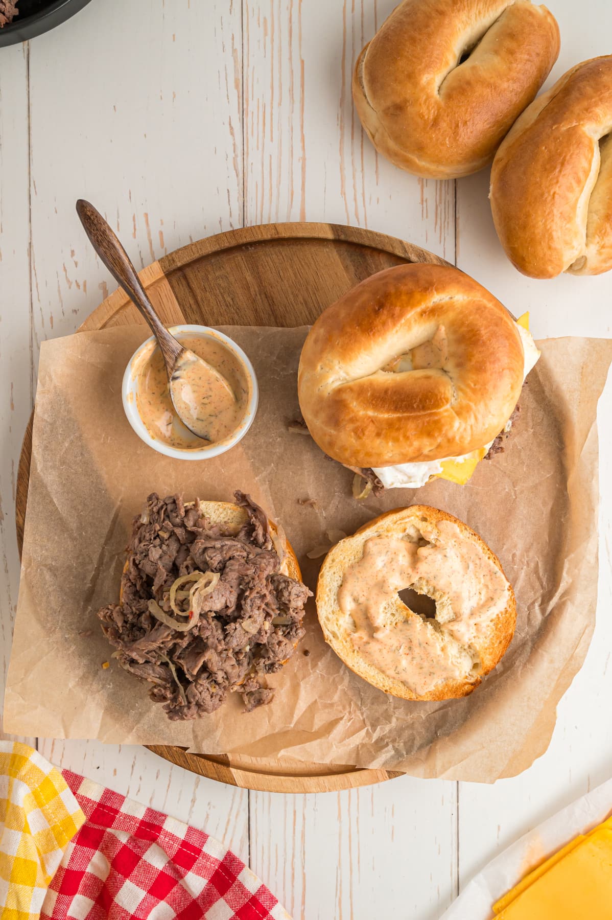 steak egg and cheese bagels on wooden board