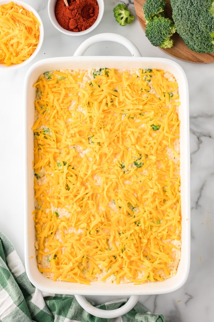 Shredded cheese added to the top of the casserole dish