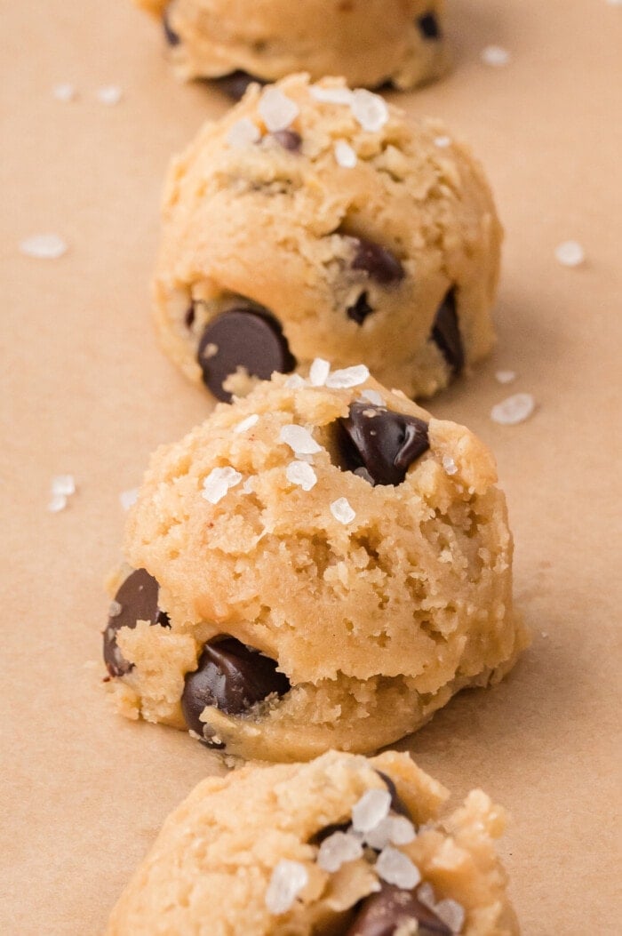 Two balls of brown butter chocolate chip cookie dough on a baking sheet
