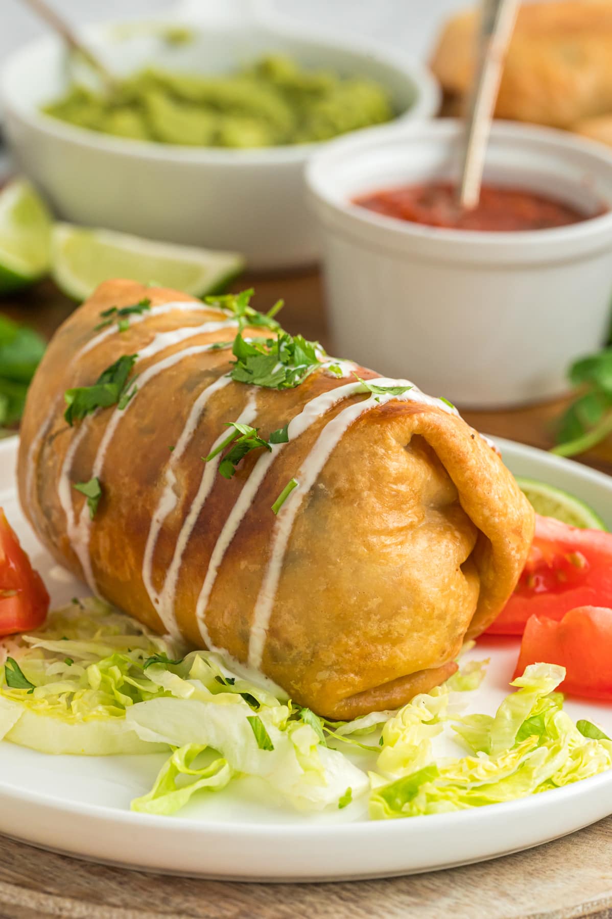 Chicken Chimichanga on plate with sour cream and salsa