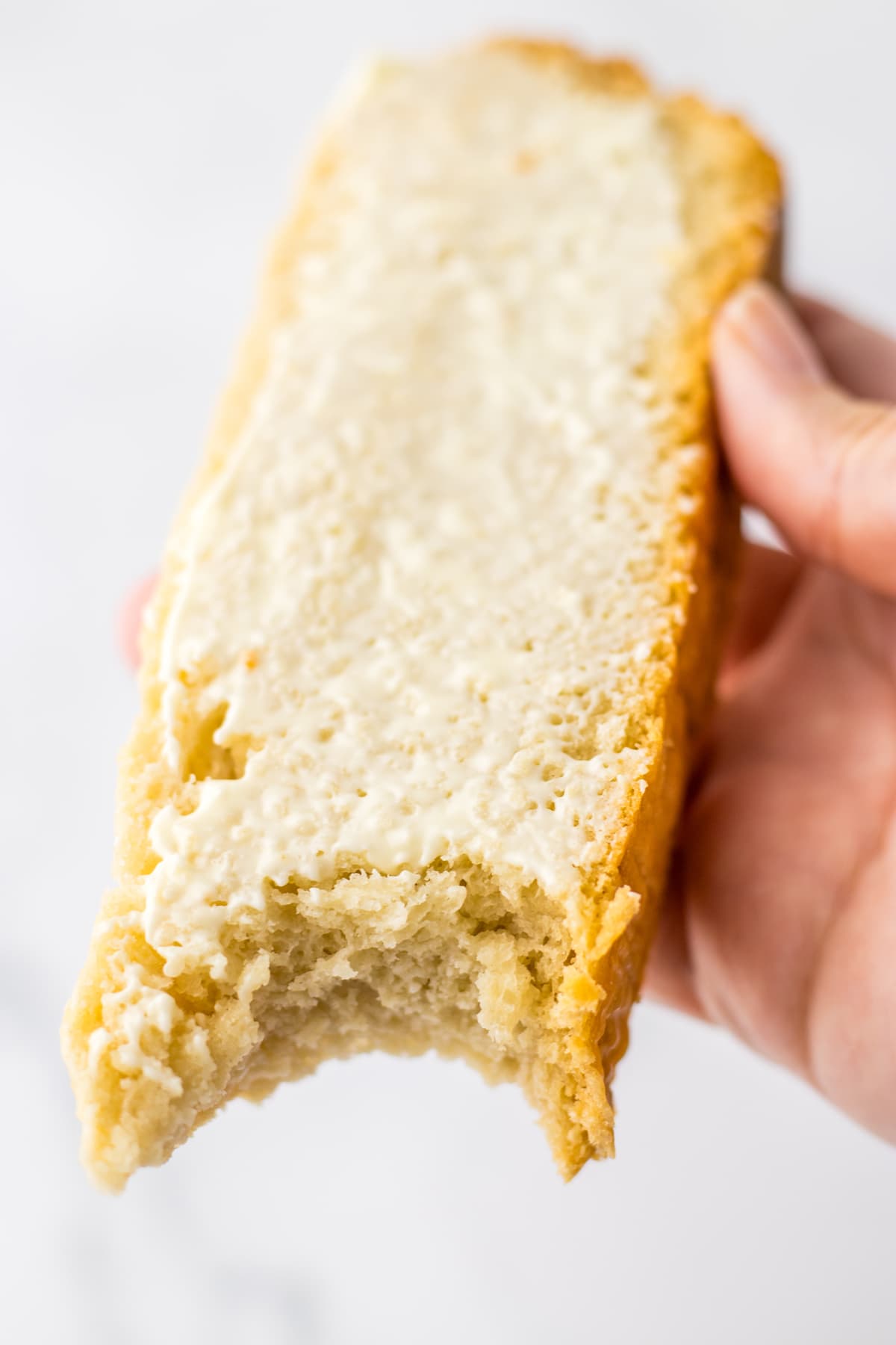hand holding slice of Crock Pot Bread with butter