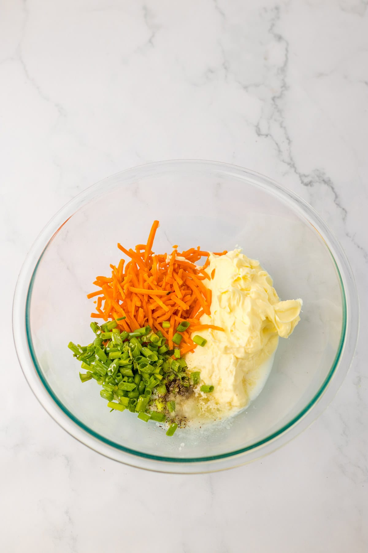 Ingredients for Hawaiian macaroni salad in a glass bowl.