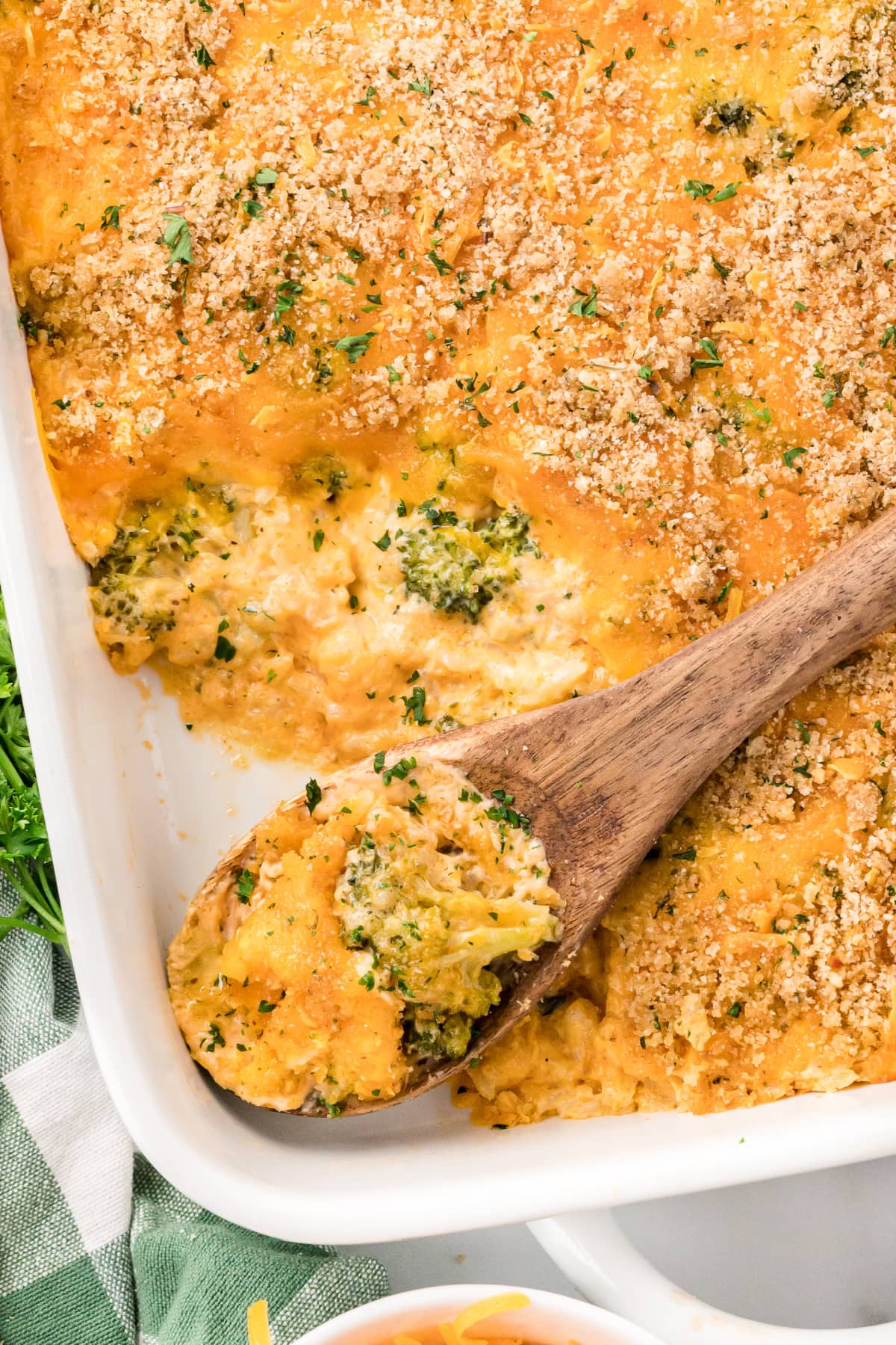 Cheesy Broccoli Rice Casserole in a baking dish with a wooden spoon