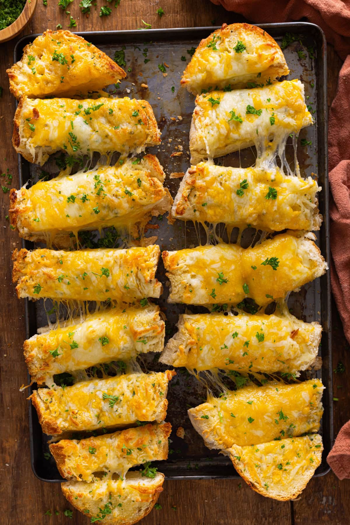 Cheesy garlic bread sticks on a baking sheet