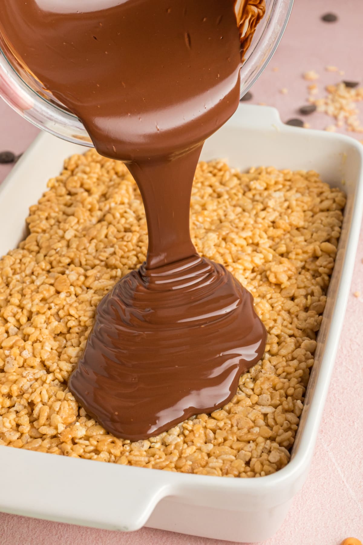 pouring chocolate over rice krispie mixture