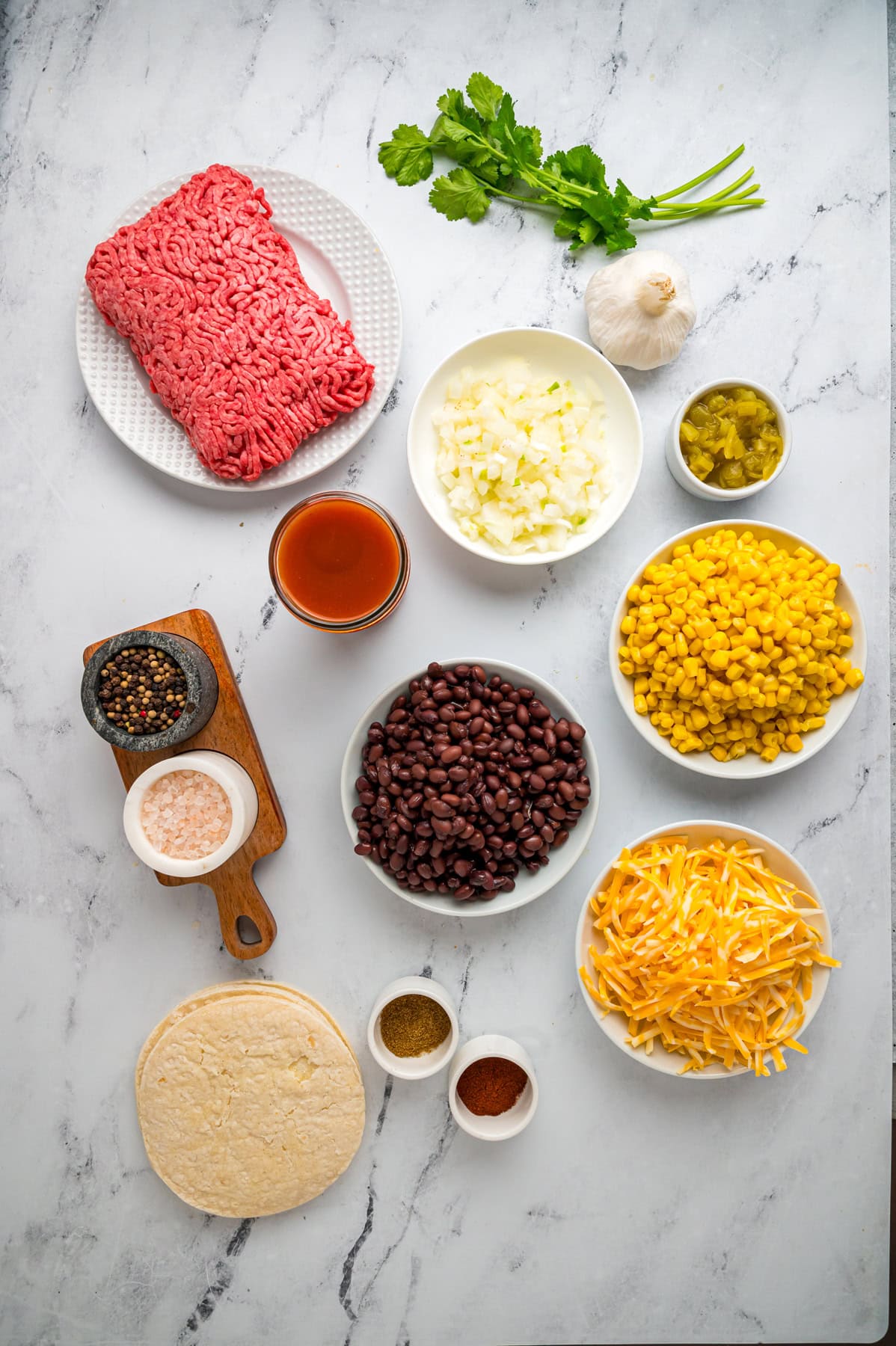 Overhead view of ingredients needed for beef enchilada casserole