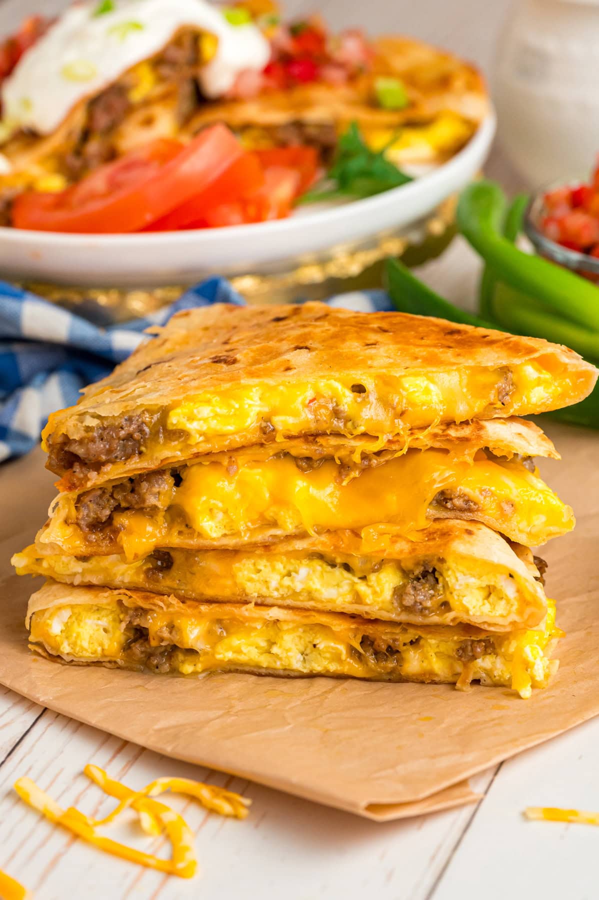 This Breakfast Quesadilla recipe is made with fluffy scrambled eggs, sausage and melted cheese stuffed inside a crispy grilled tortilla. Cut breakfast quesadillas stacked on top of each other.