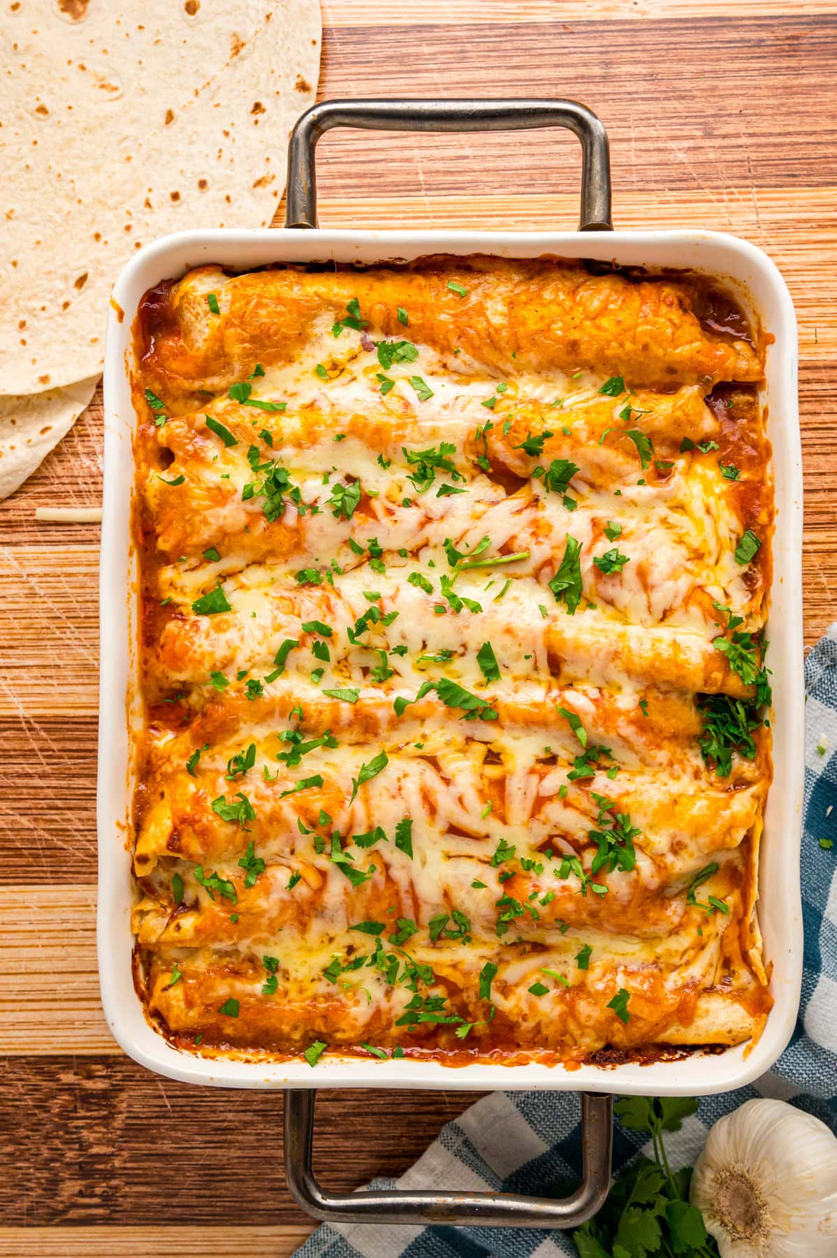 With a seasoned shredded chicken and cheese filling and red enchilada sauce, this Easy Chicken Enchiladas recipe packs in the Tex-Mex flavor. Overhead view of a casserole dish of chicken enchiladas