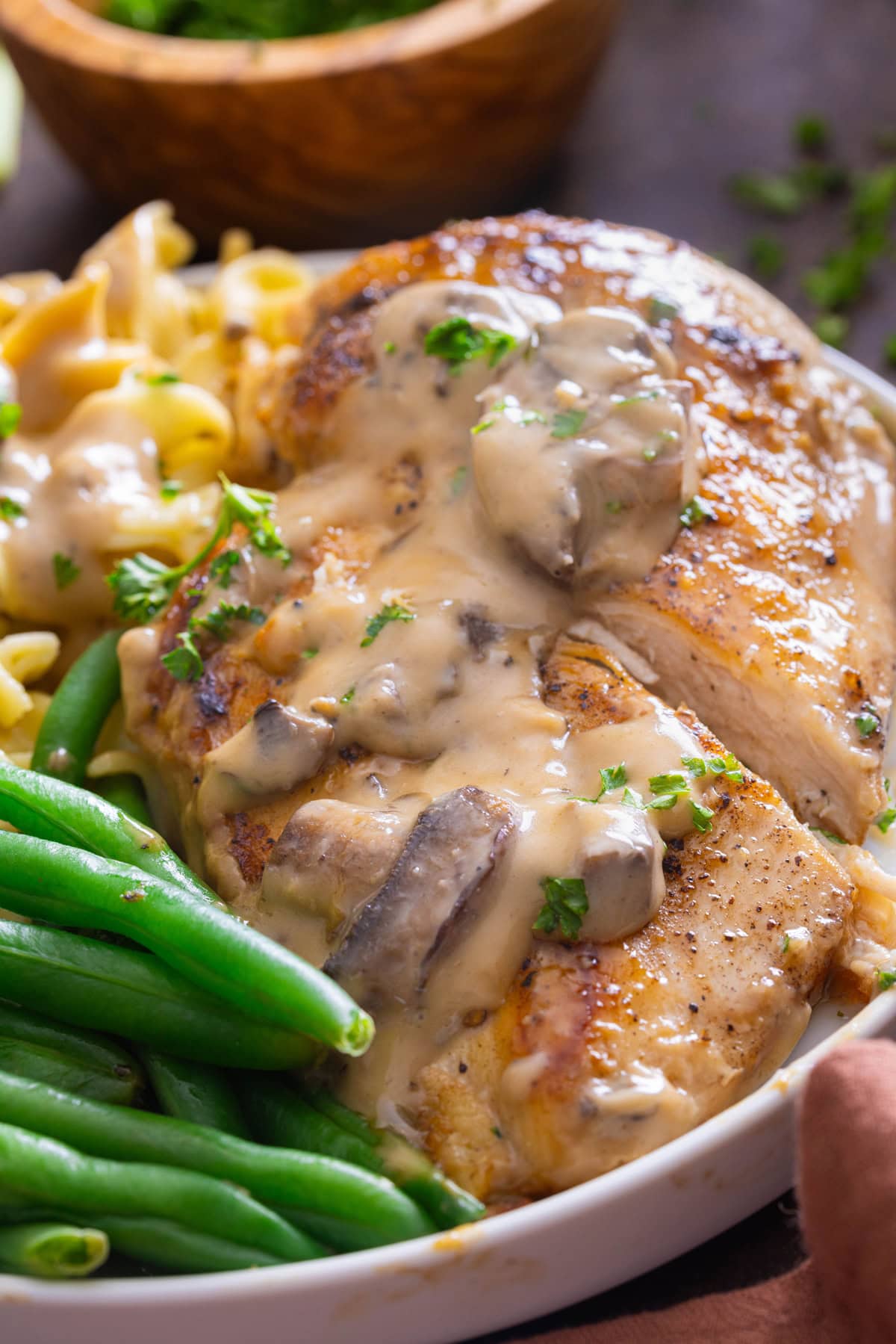 Cream of Mushroom Chicken on white plate with green beans
