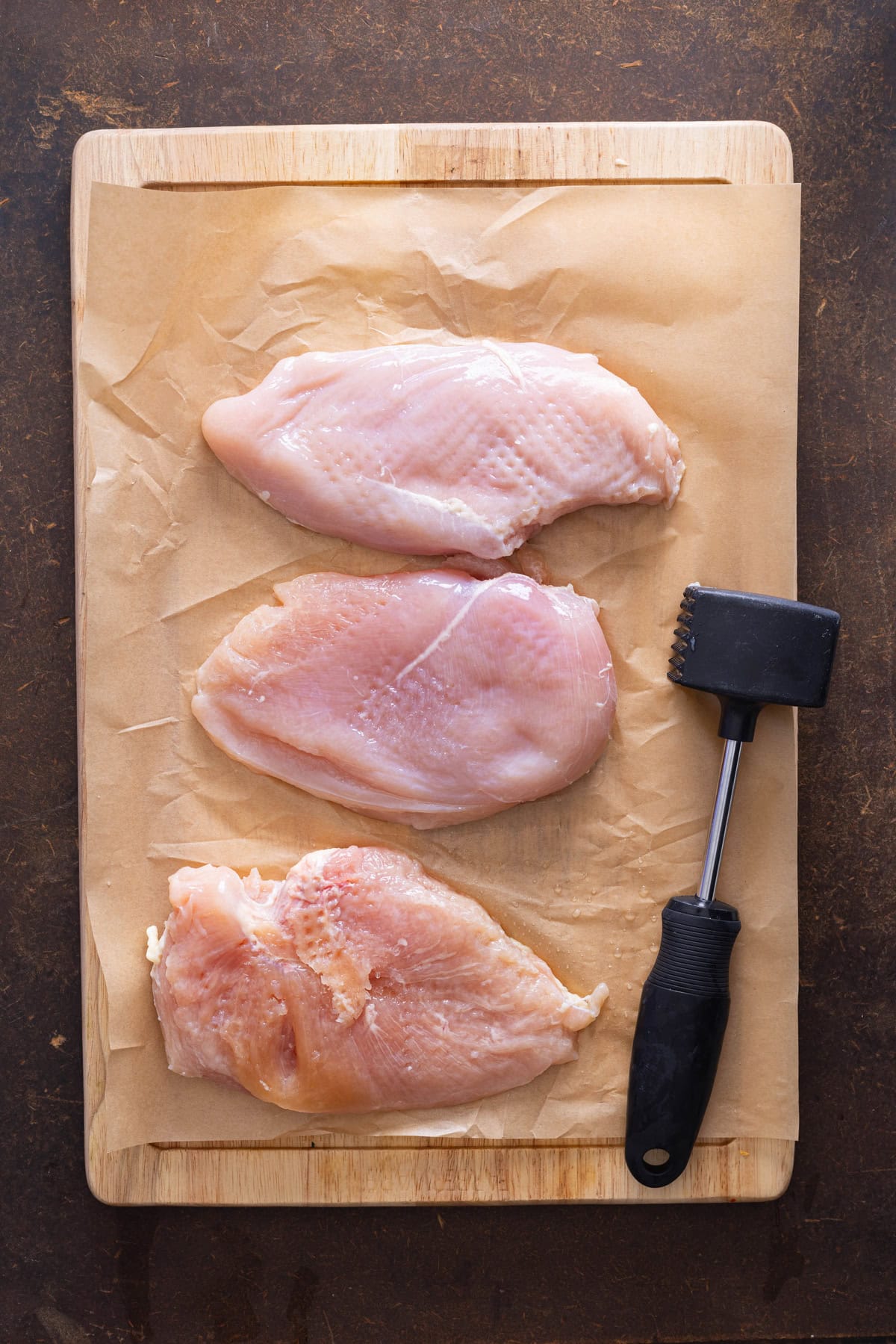 chicken on parchment paper pounded out flat