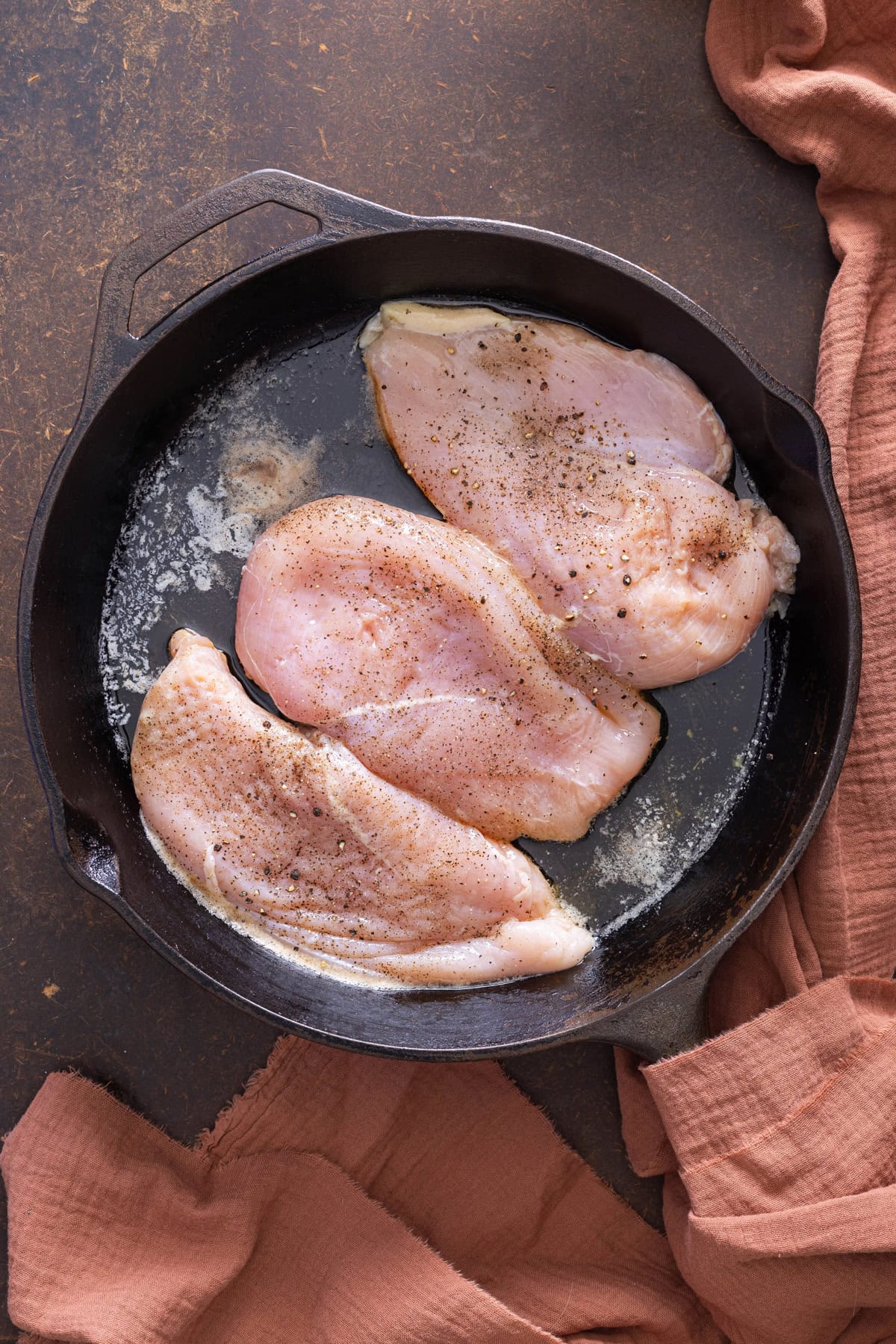 chicken cooking in cast iron skillet