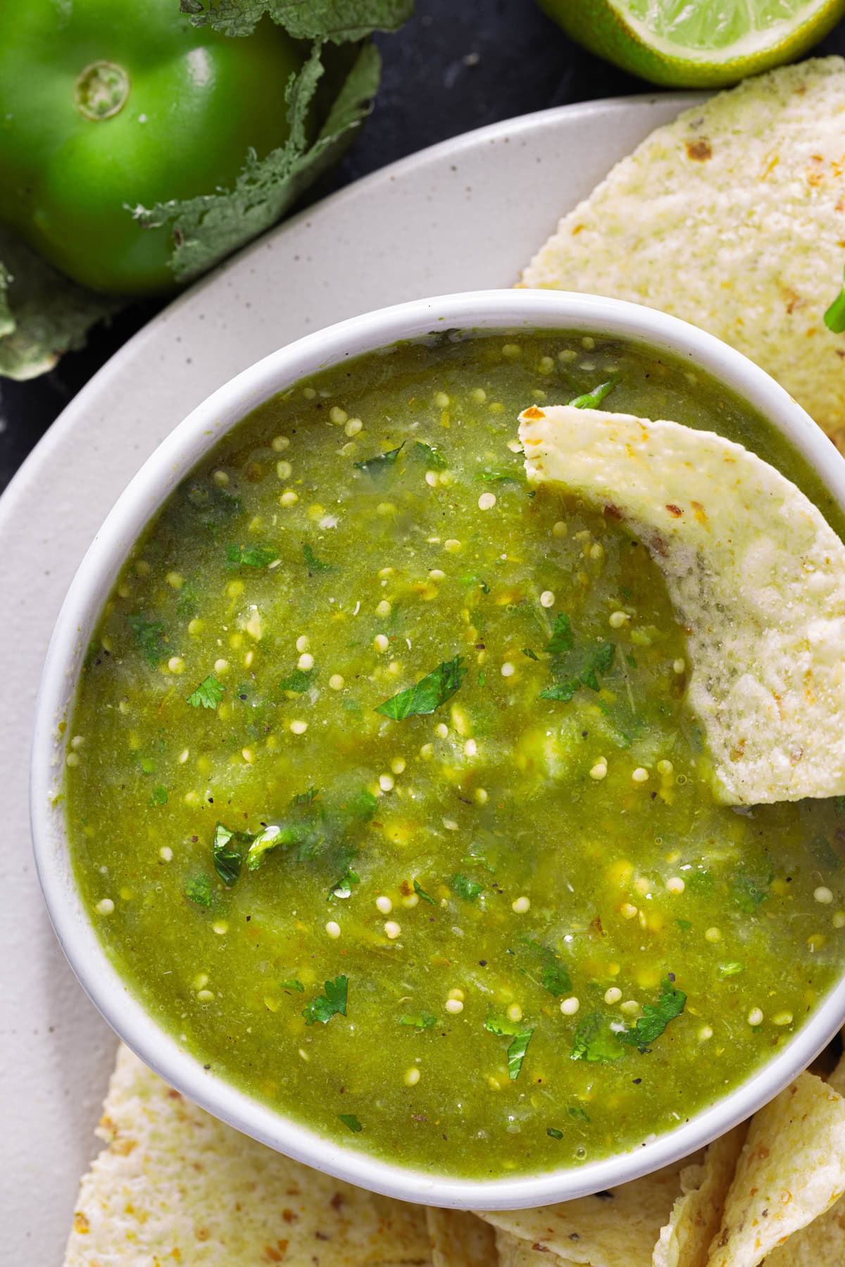 Made with roasted tomatillos, jalapenos, onions, and garlic, this Mexican Salsa Verde recipe offers a mild but robust flavor. A tortilla chip dipped in a bowl of salsa verde
