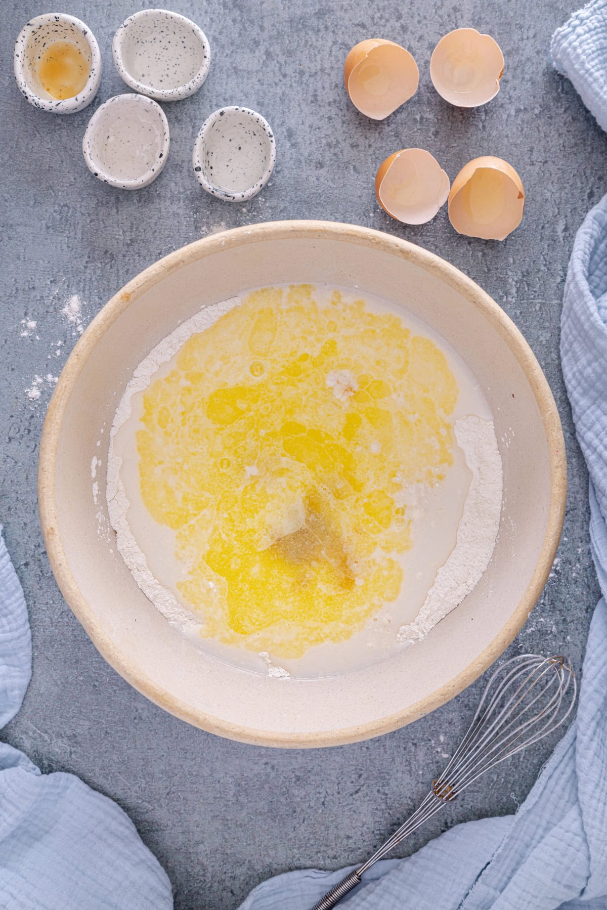 Melted butter and eggs added to flour in a mixing bowl to make the batter for Sheet Pan Pancakes.