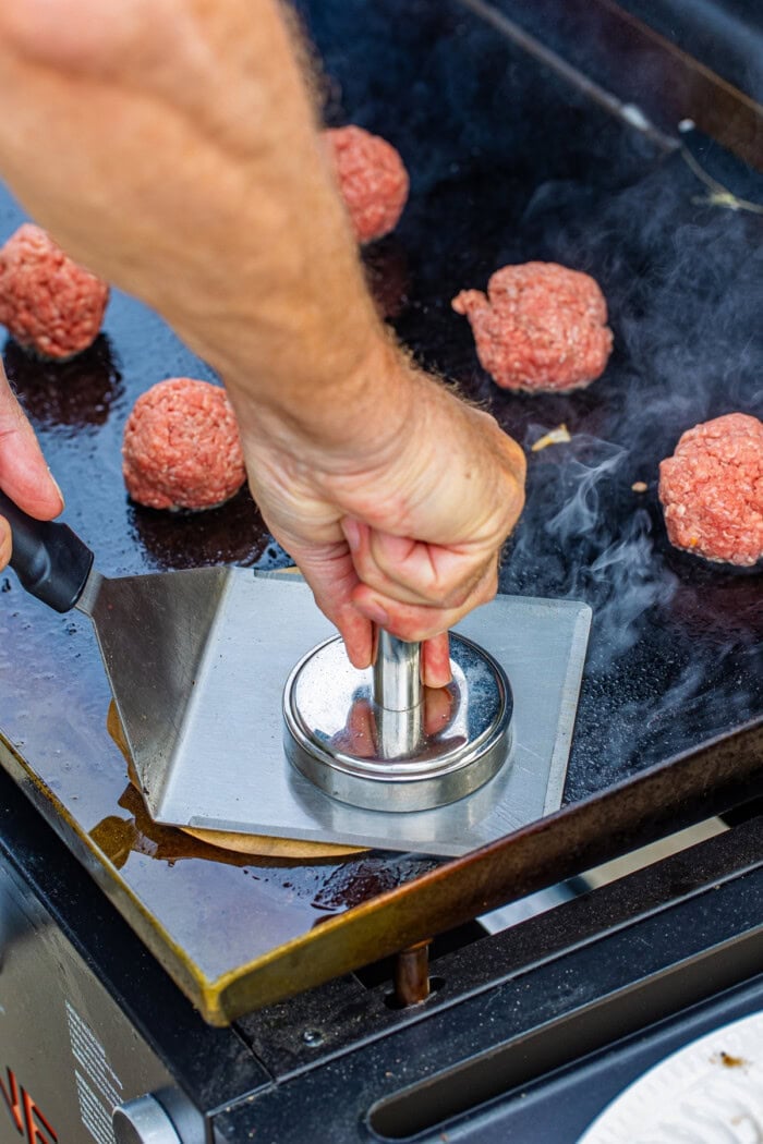 A weight smashing a burger patty