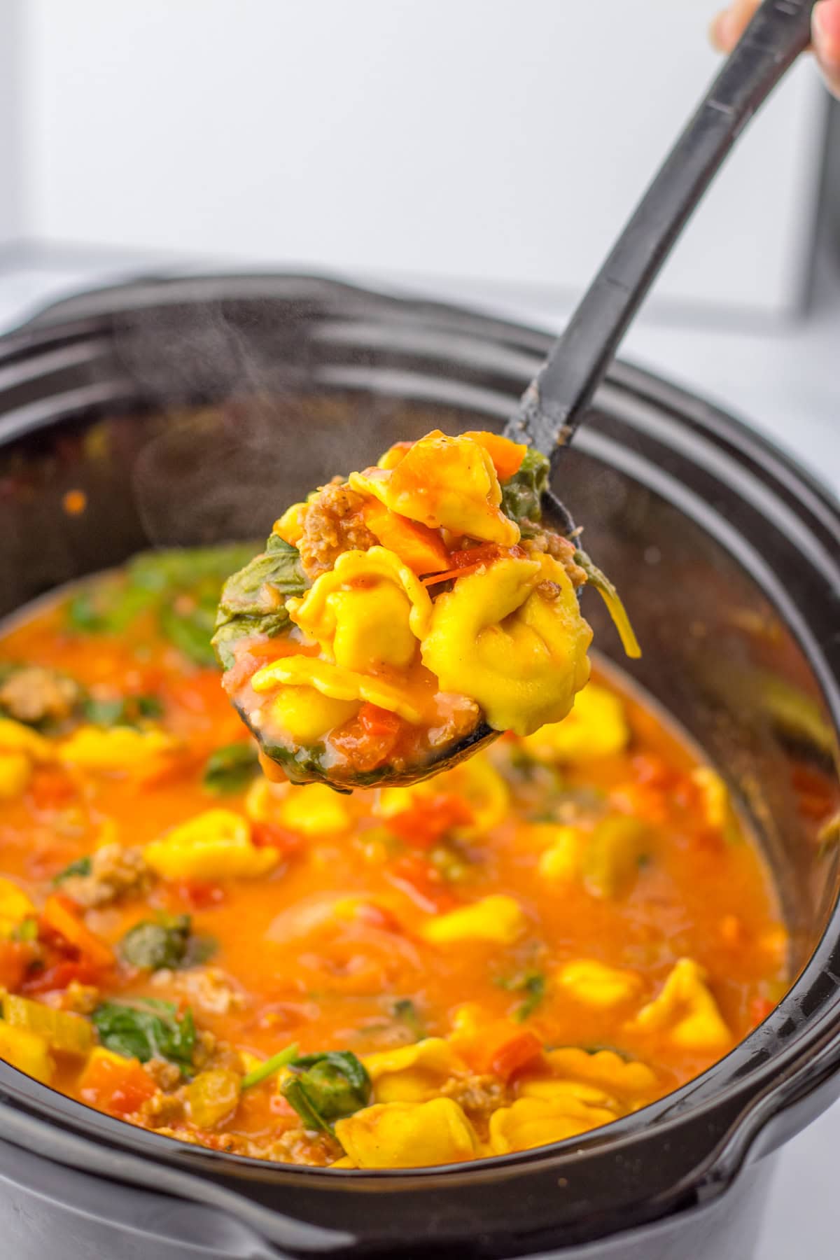 This savory and flavorful recipe for Crockpot Tortellini Soup is great any night of the week. It’s a comforting meal that even tastes delicious for lunch the next day. Serving a Crockpot Tortellini Doup recipe from a slow cooker.