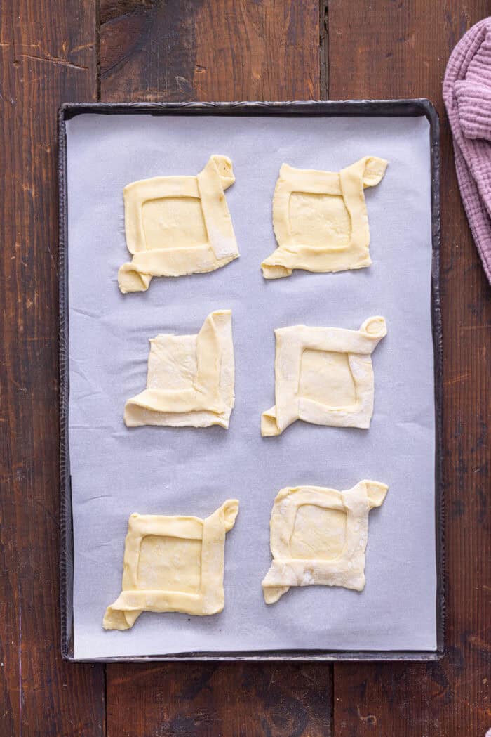 Puff pastry squares on a baking sheet
