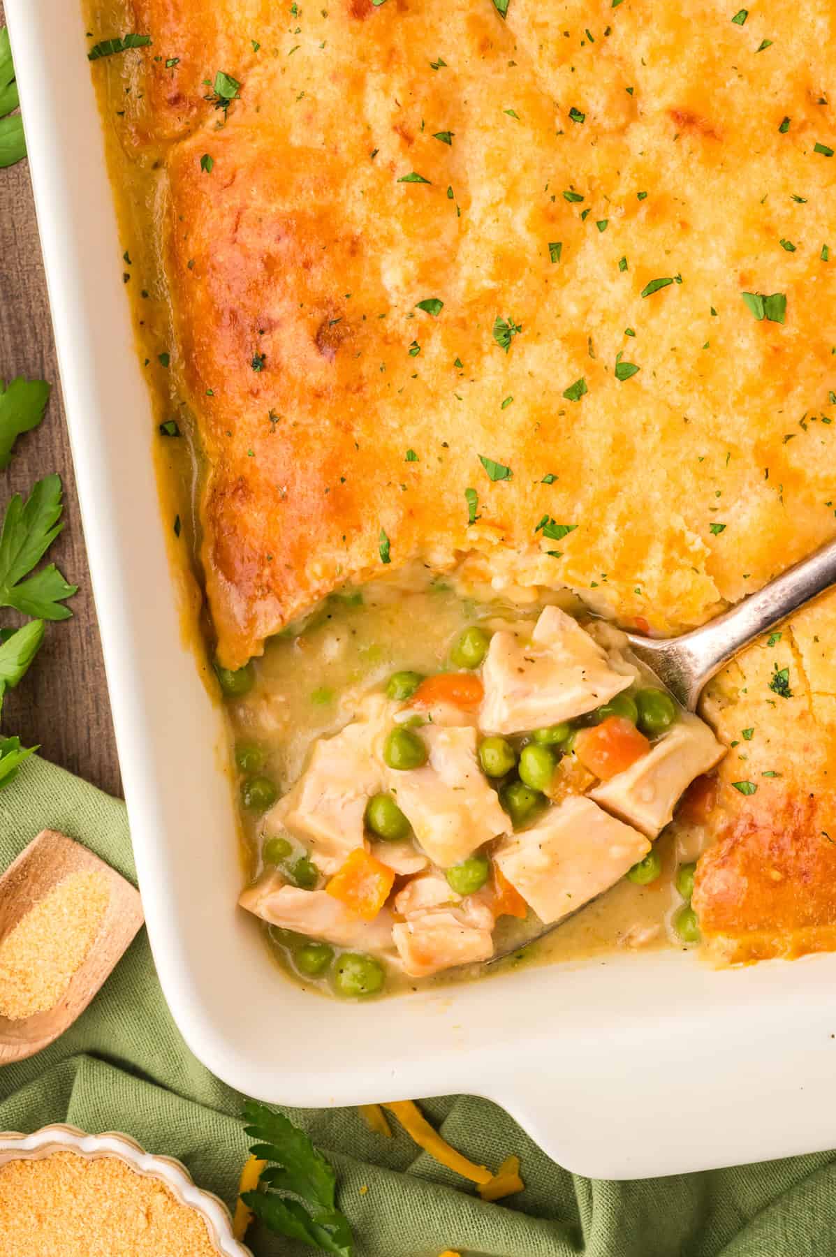 A spoon in a baking dish of chicken cobbler