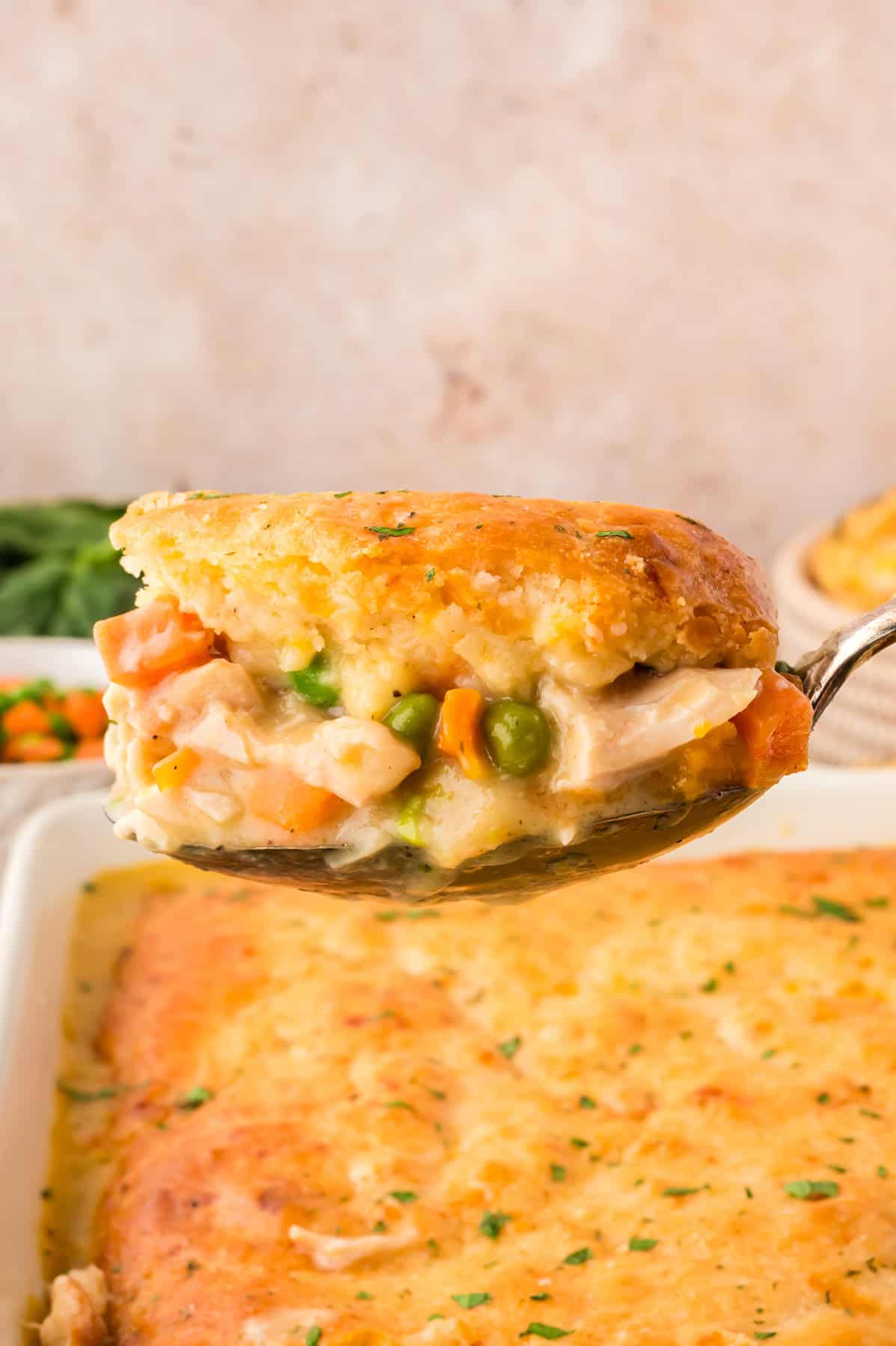Made with rotisserie chicken, frozen veggies, and Cheddar Bay biscuit mix, this Chicken Cobbler recipe is an easy weeknight dinner. A spoonful of chicken cobbler with Red lobster biscuits held over the baking dish