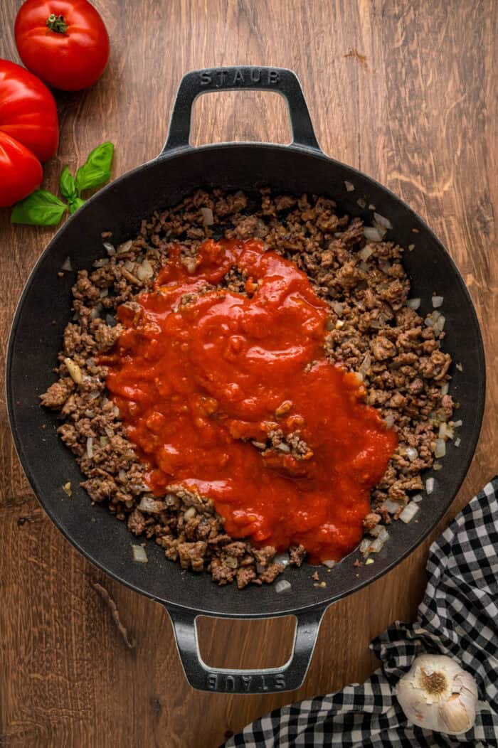 Marinara sauce with ground beef and sausage in a skillet