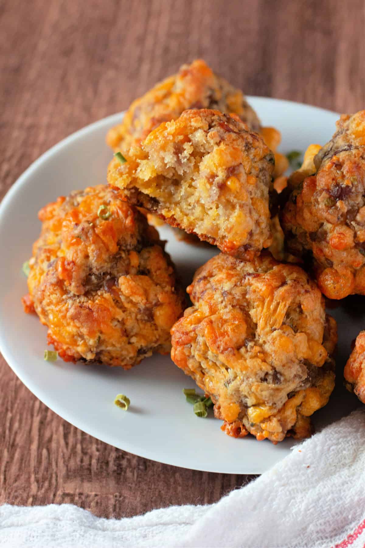 A plate of sausage balls stacked on top of each other, showcasing the golden, crispy exterior.
