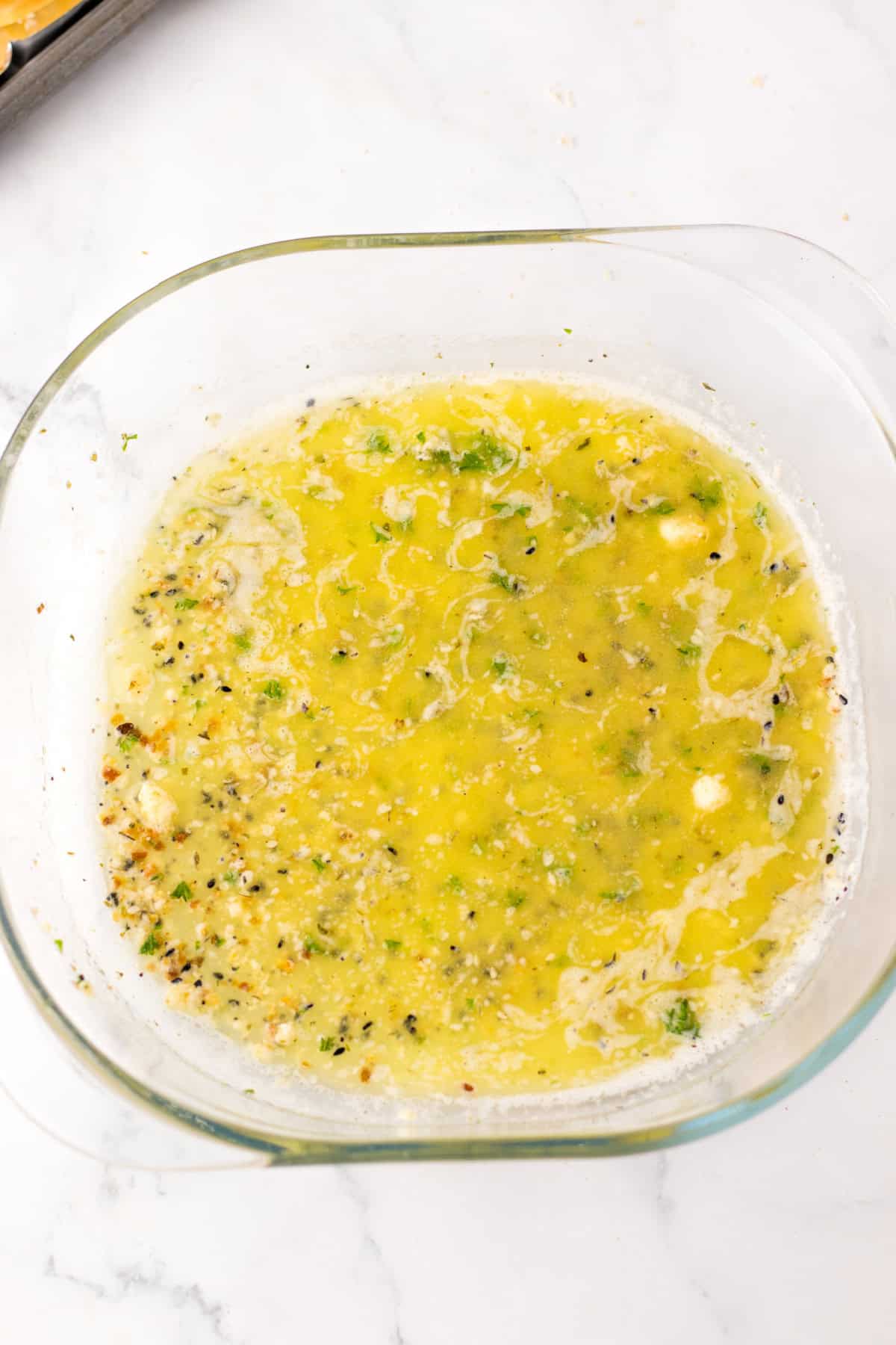 melted butter and seasoning in glass bowl
