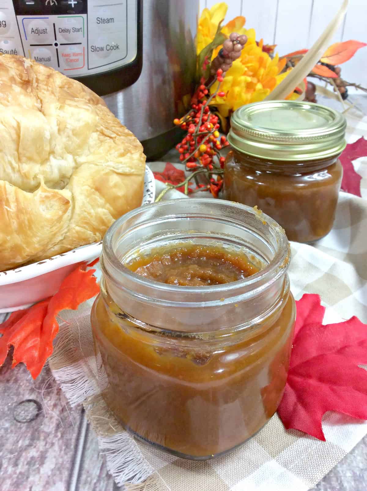 Jars of Sweet Potato Butter placed near fresh baked bread, ready to be served.