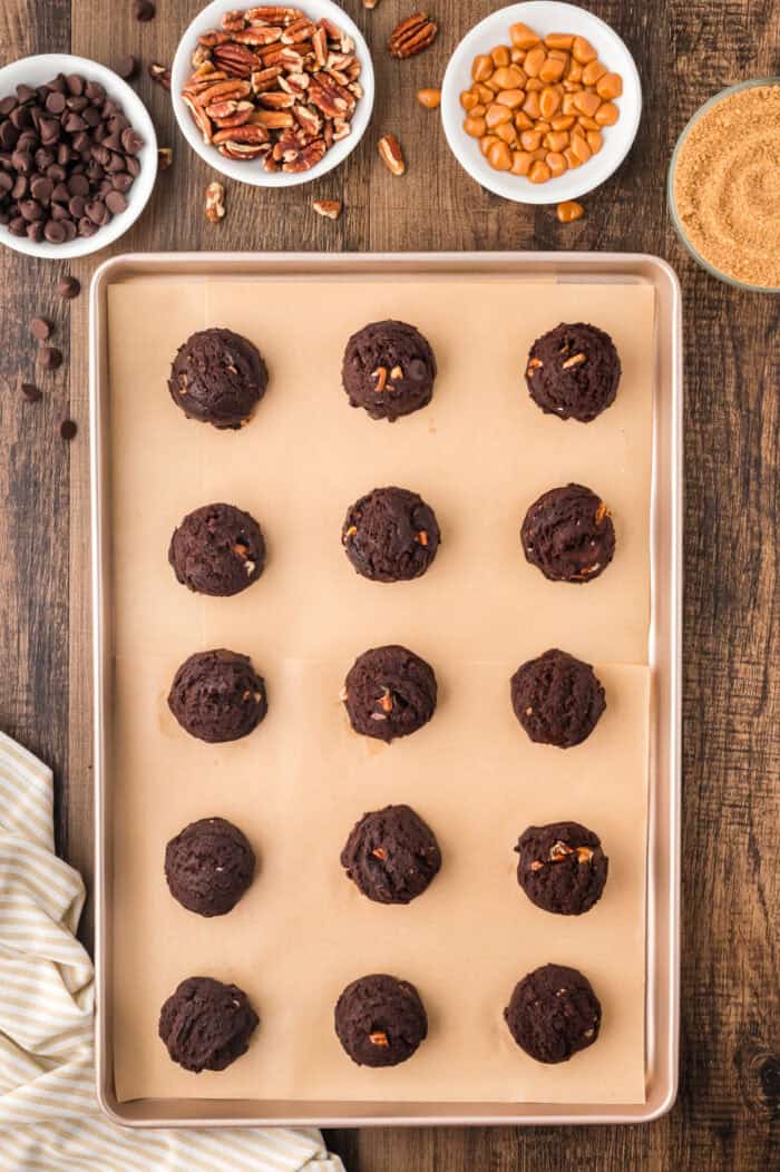 Balls of chocolate cookie dough on a baking sheet