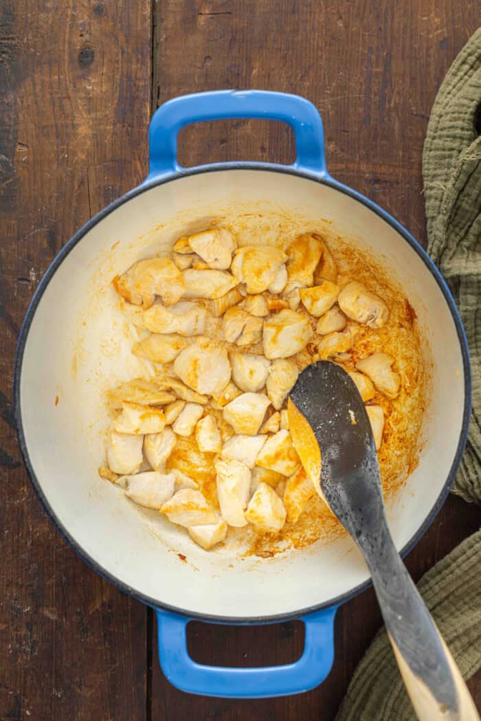 Diced chicken cooking in a skillet