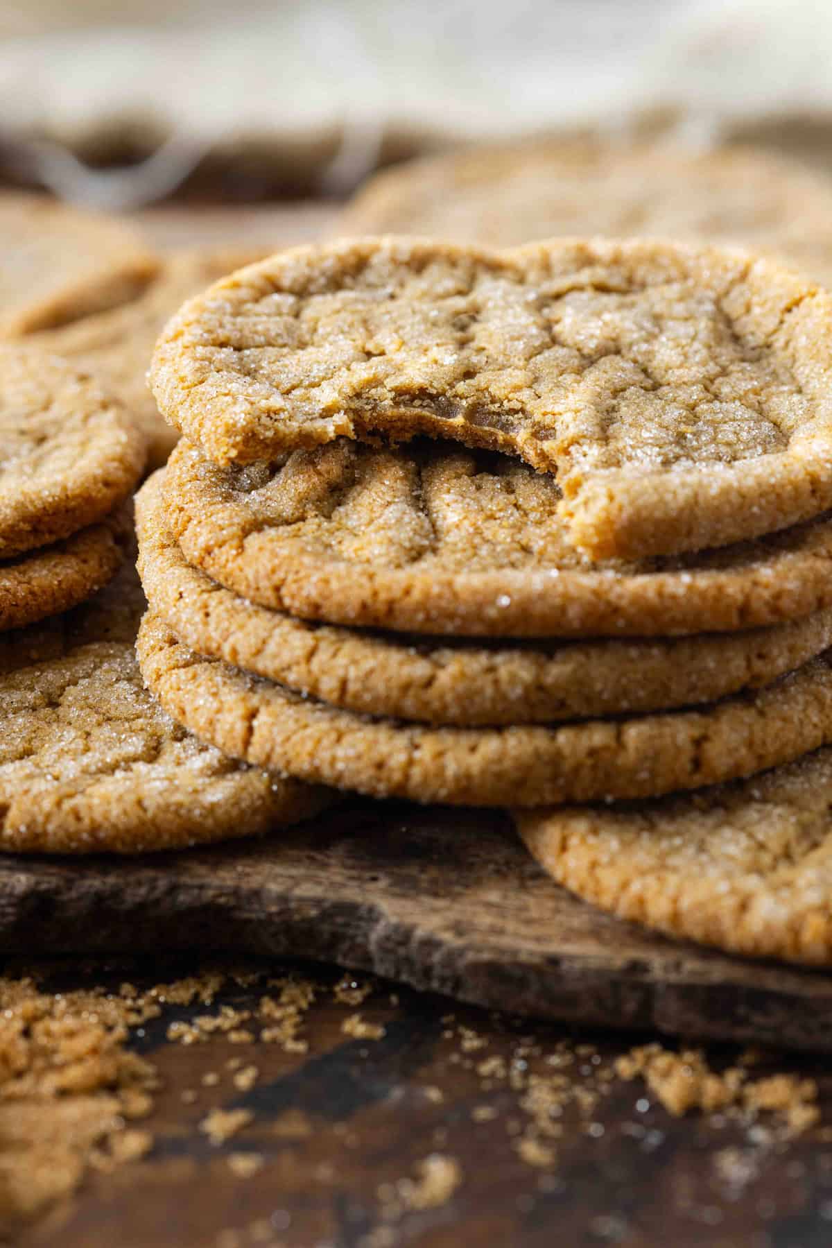 A stack of brown sugar cookies, the top one with a bite missing