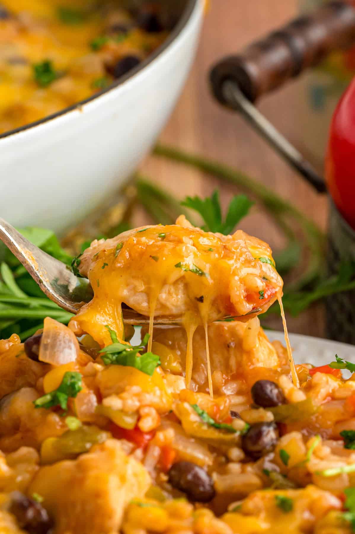 A bite of cheesy fiesta chicken on a fork