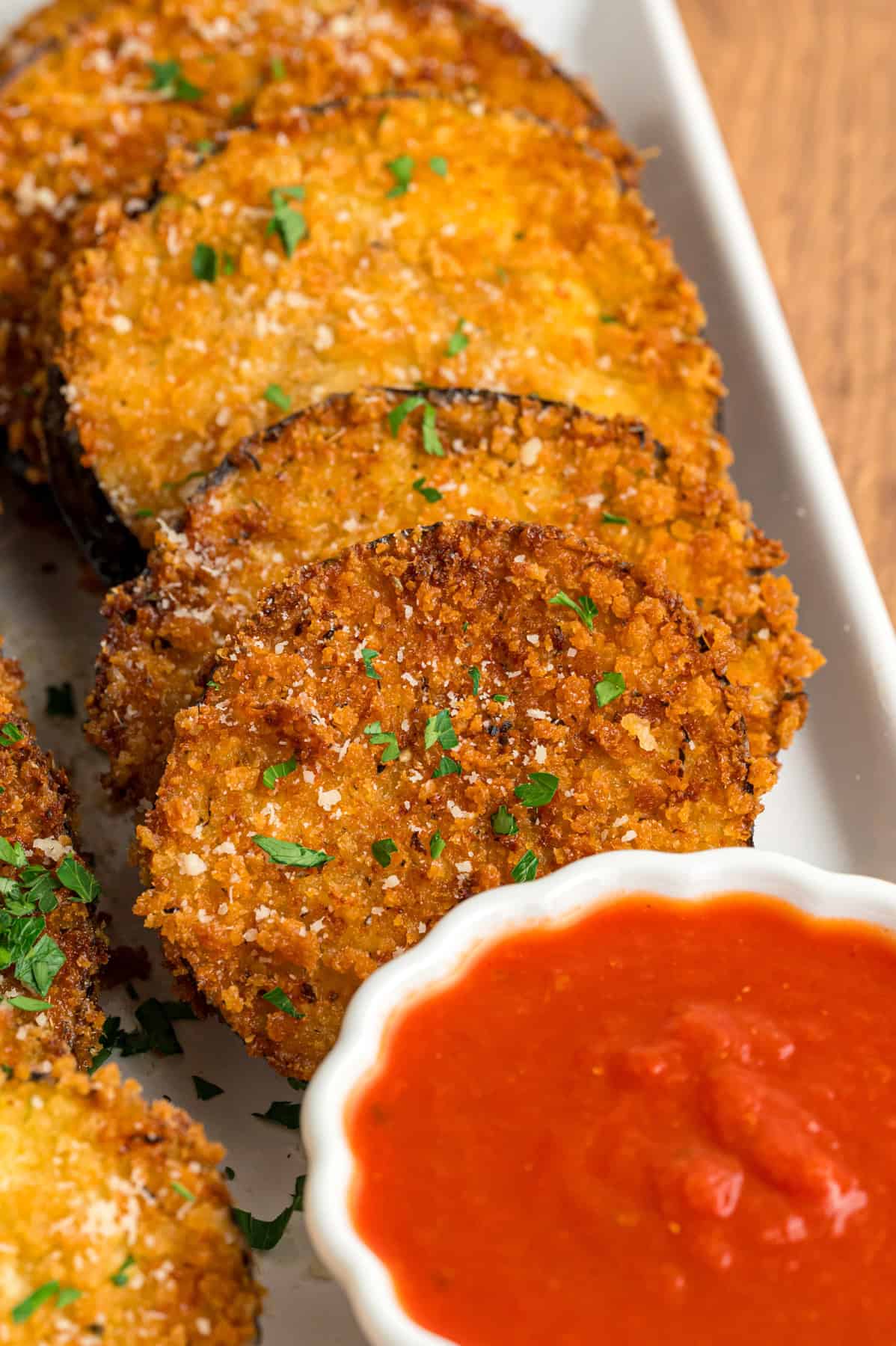 Seasoned panko breadcrumbs give this Fried Eggplant a light, crispy texture and savory flavor. Serve with marinara sauce for a quick, easy appetizer to your next Italian dinner. Slices of fried eggplant on a plate