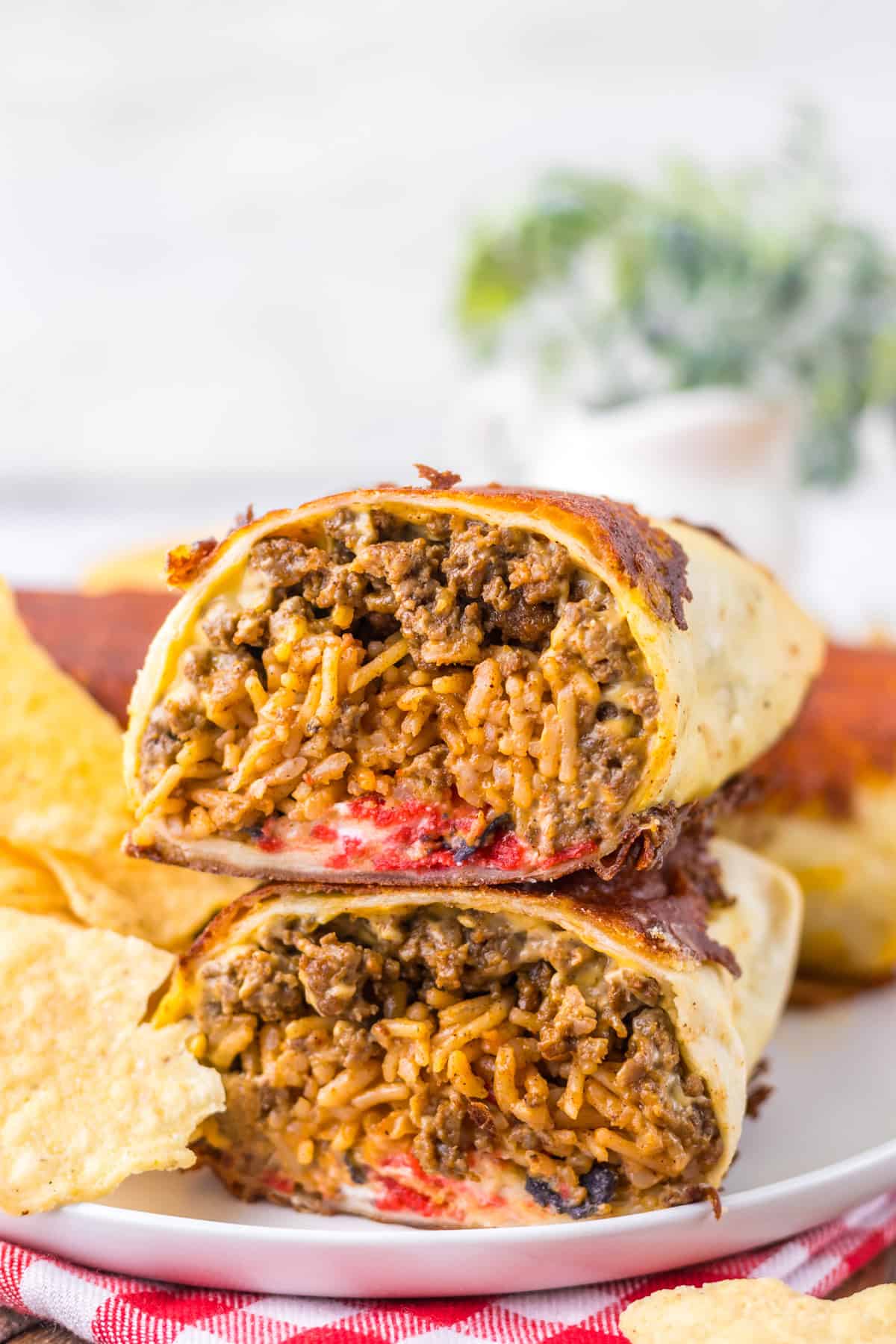 Tortillas are stuffed with Mexican rice, taco meat, nacho cheese, chipotle sauce, and more in this Taco Bell Grilled Cheese Burrito recipe. Close up of two halves of grilled cheese burritos