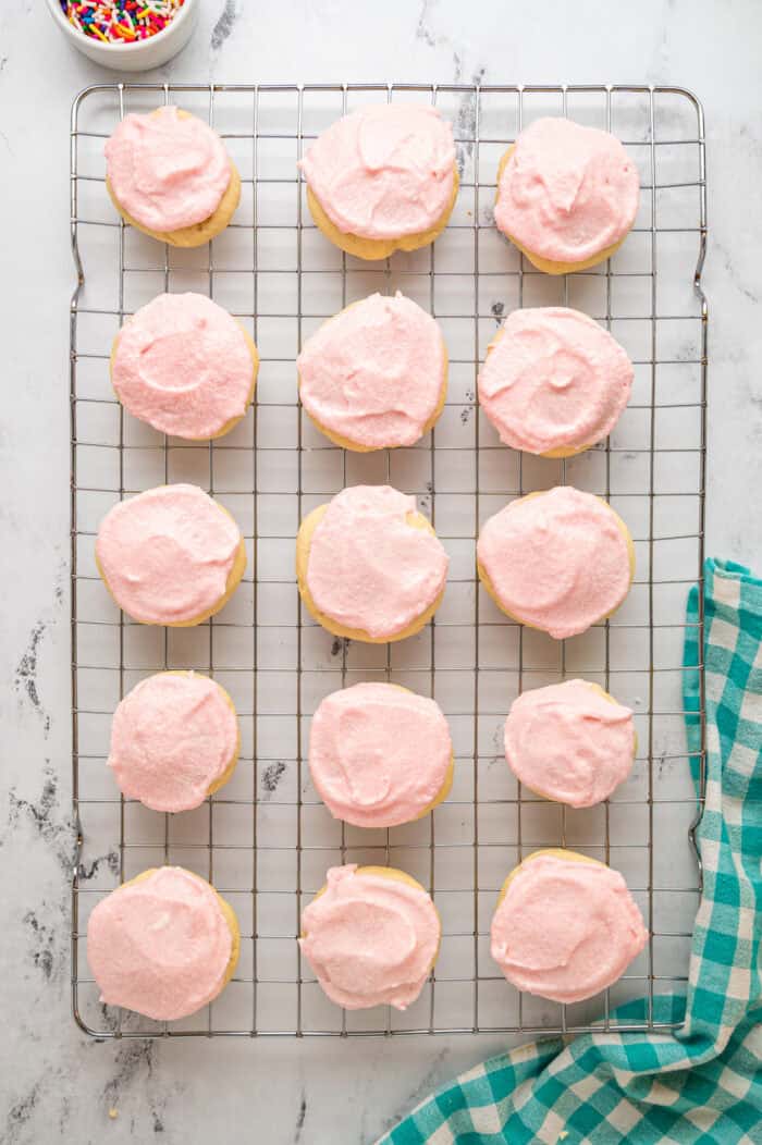 Lofthouse cookies with pink frosting on a cooling rack