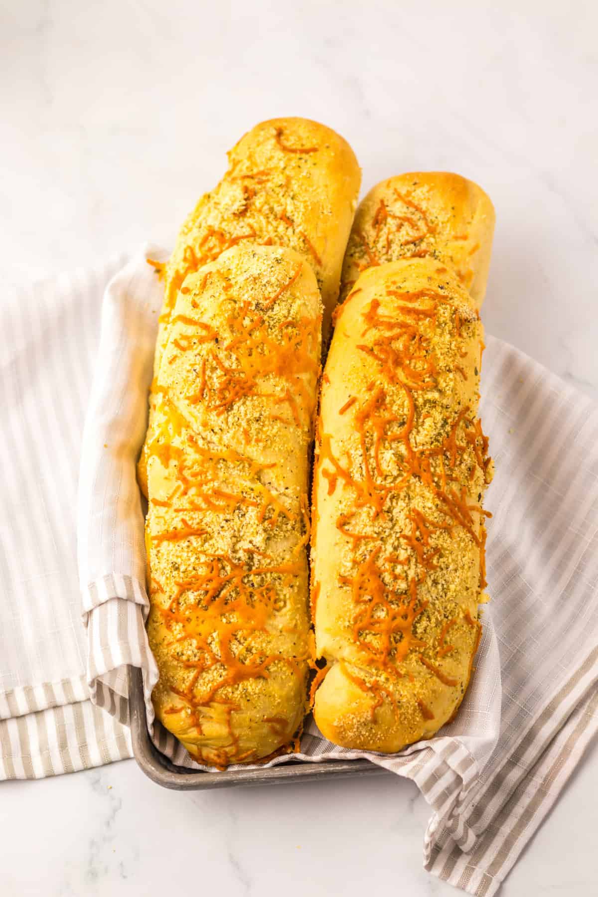 Italian Herb Cheese Bread in pan with tan napkin