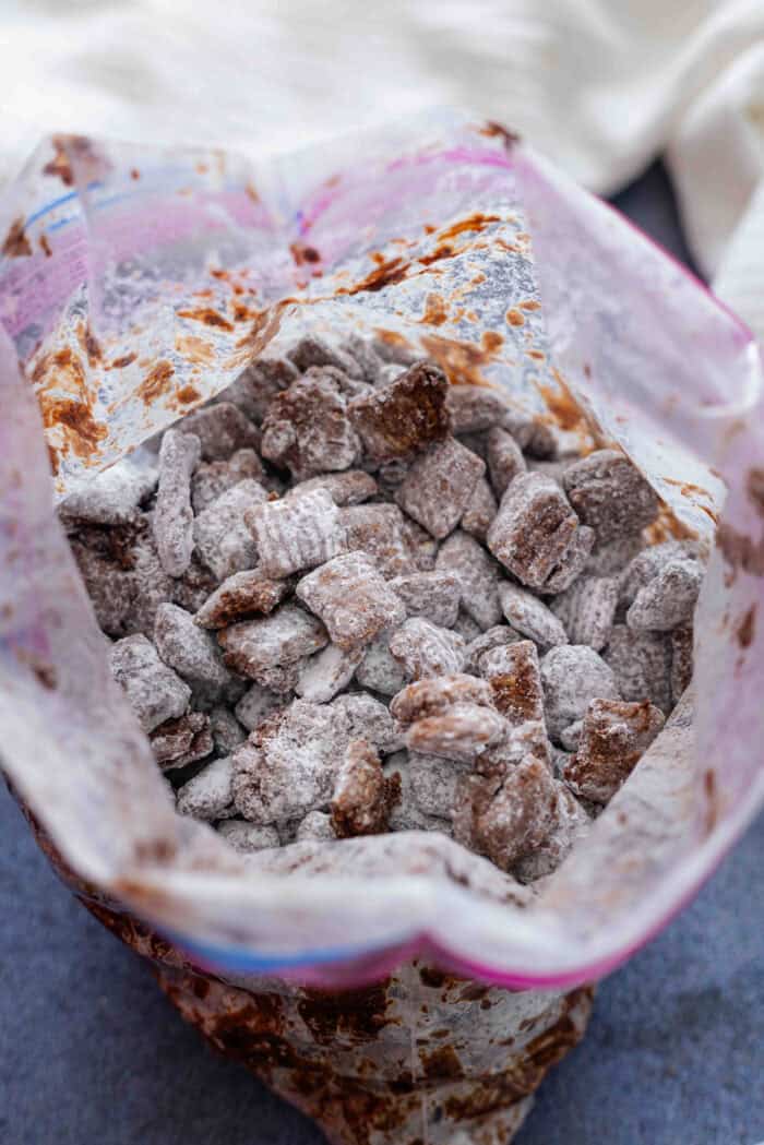 Chocolate covered Chex cereal and powdered sugar in a ziploc bag