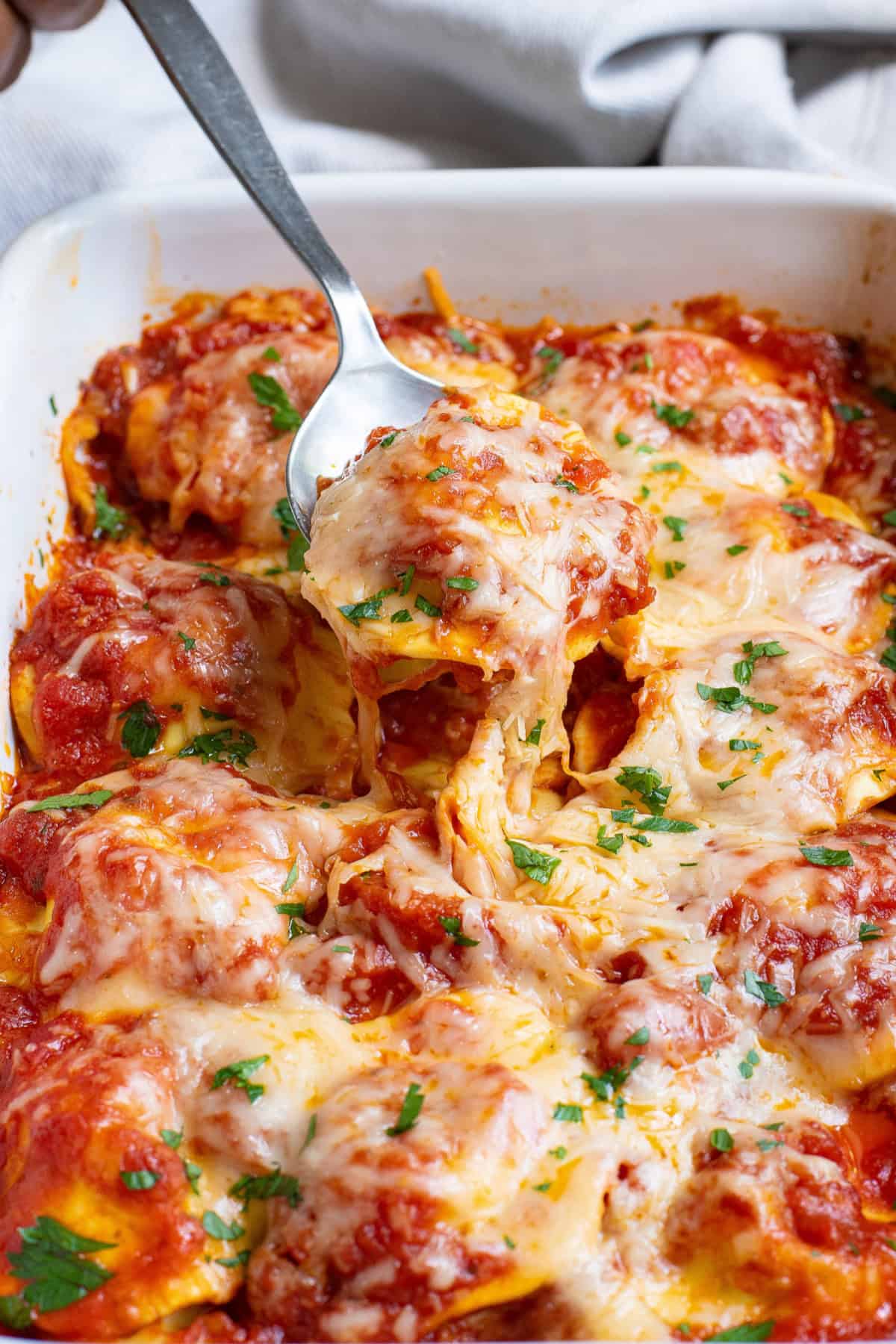 This Baked Ravioli is a super simple dinner made with just 3 ingredients in under 30 minutes. Baked Ravioli with a serving spoon