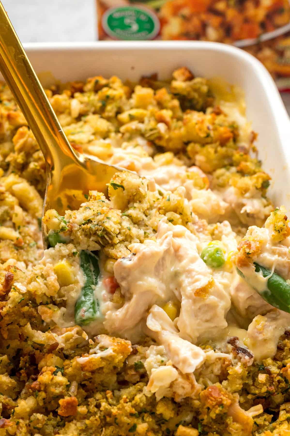 A spoon in a baking dish of chicken and stuffing casserole