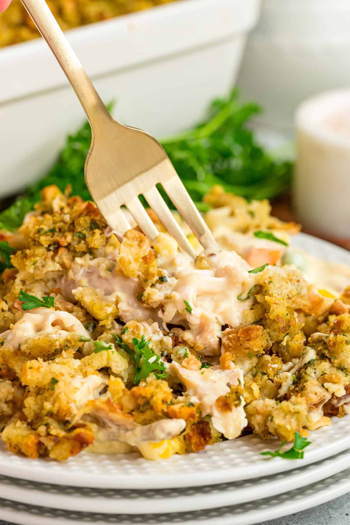A fork on a plate of chicken and stuffing casserole