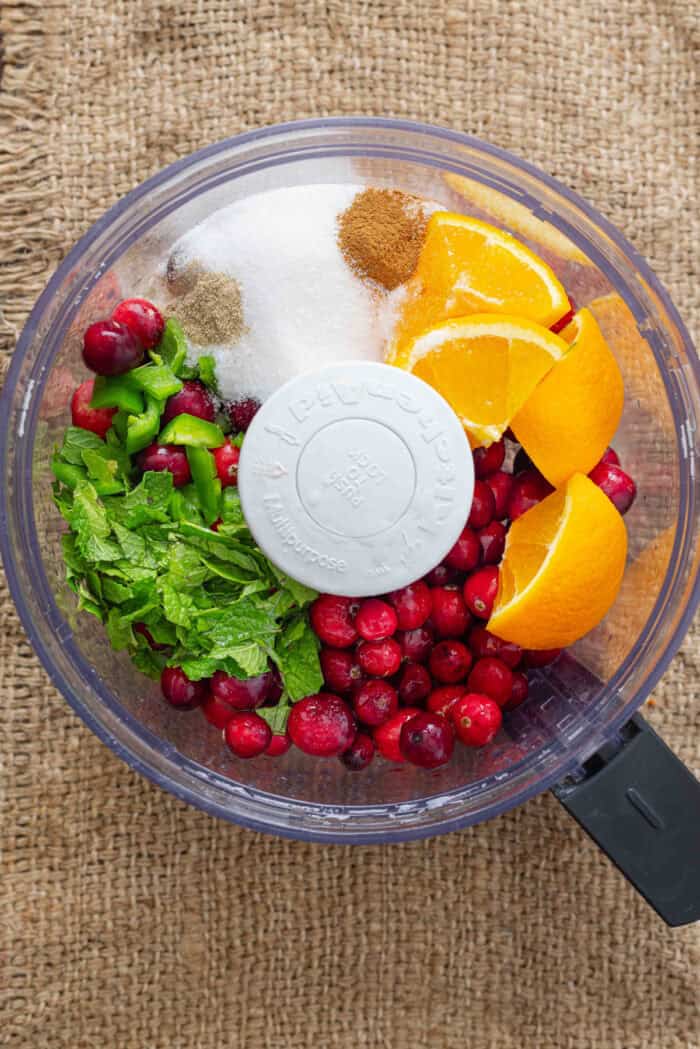Oranges, sugar, jalapeno, cranberries, and spices in a food processor