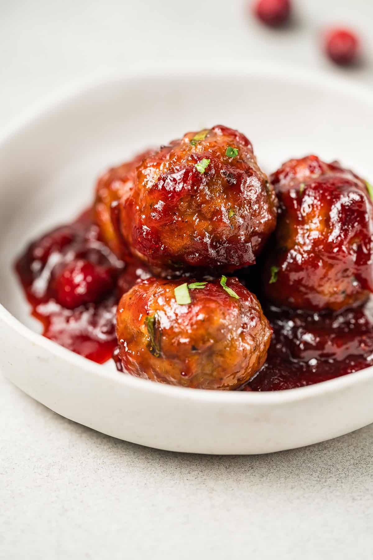 Cranberry Meatballs are a delightful blend of savory and sweet, with cranberry sauce, BBQ sauce, and brown sugar. Easy appetizer or entree! A plate of cranberry meatballs