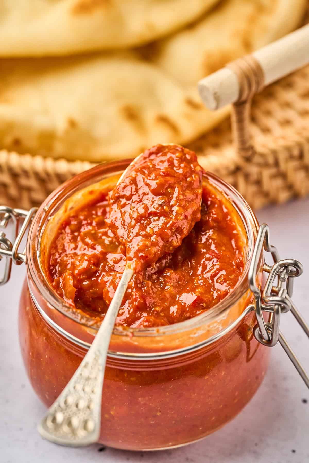 A spoon over a jar of harissa sauce